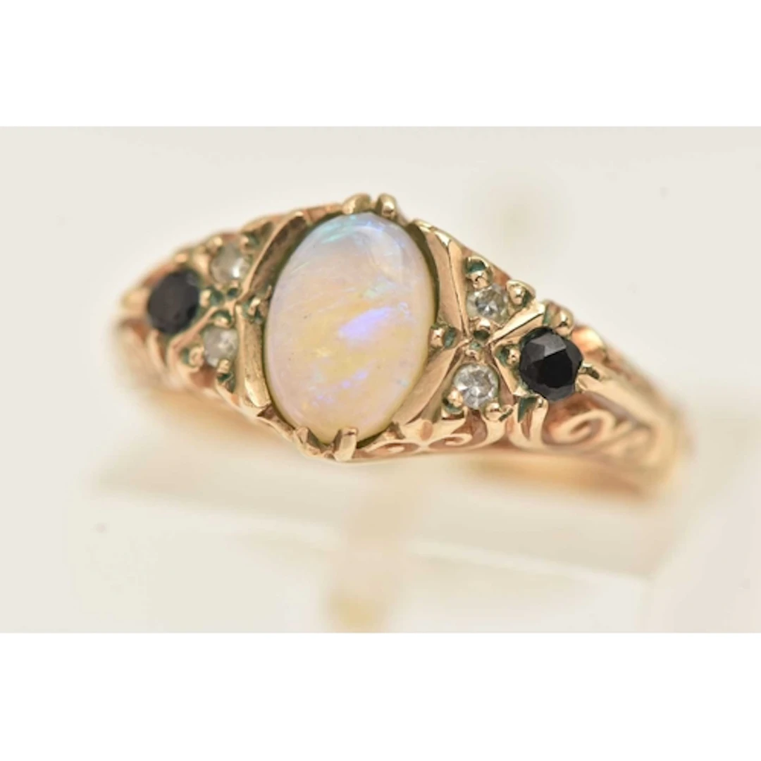 A 9CT GOLD OPAL AND GEM SET RING, set with a central oval cu...