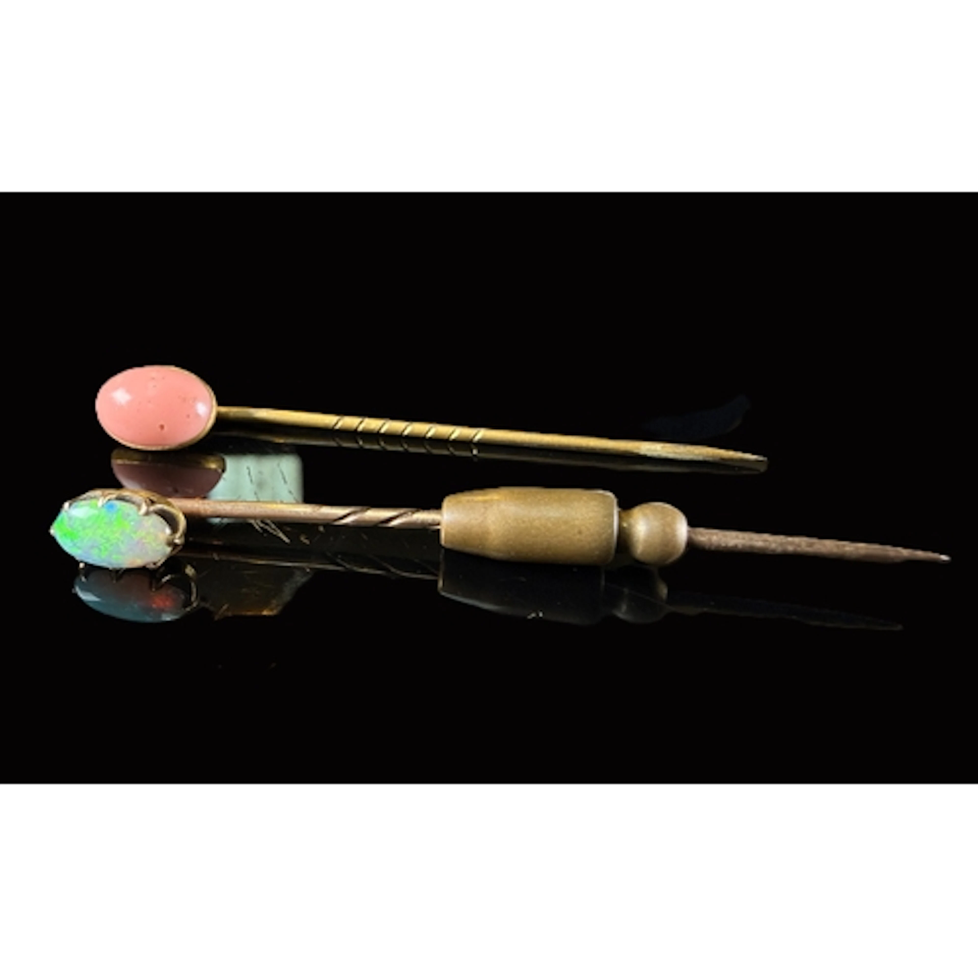 A yellow metal stick pin set with oval opal tests 9ct and an...