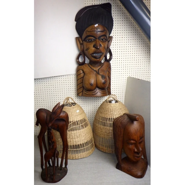A carved tribal wall hanging, two further carvings and two b...