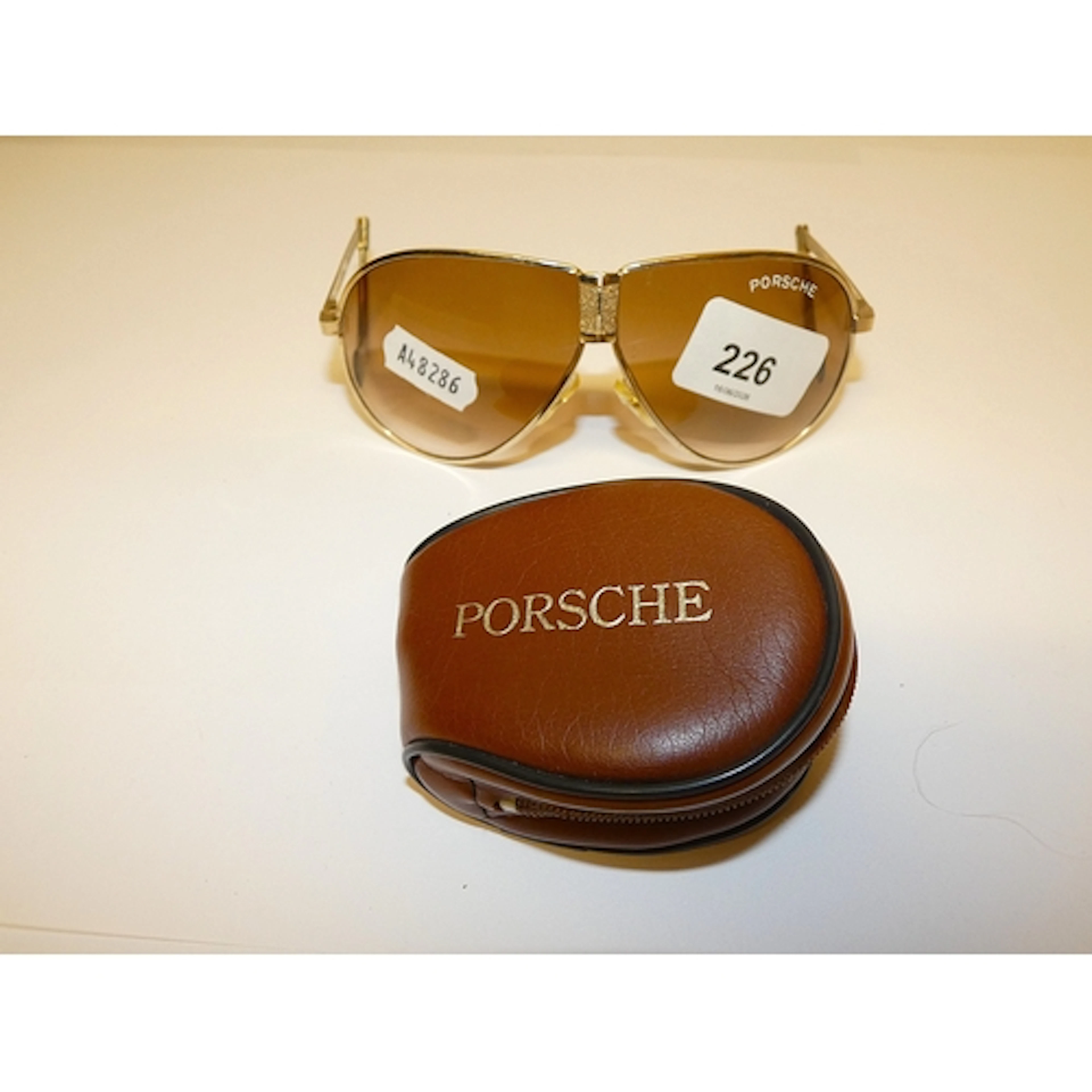 Pair of Porsche fold away sunglasses with case.