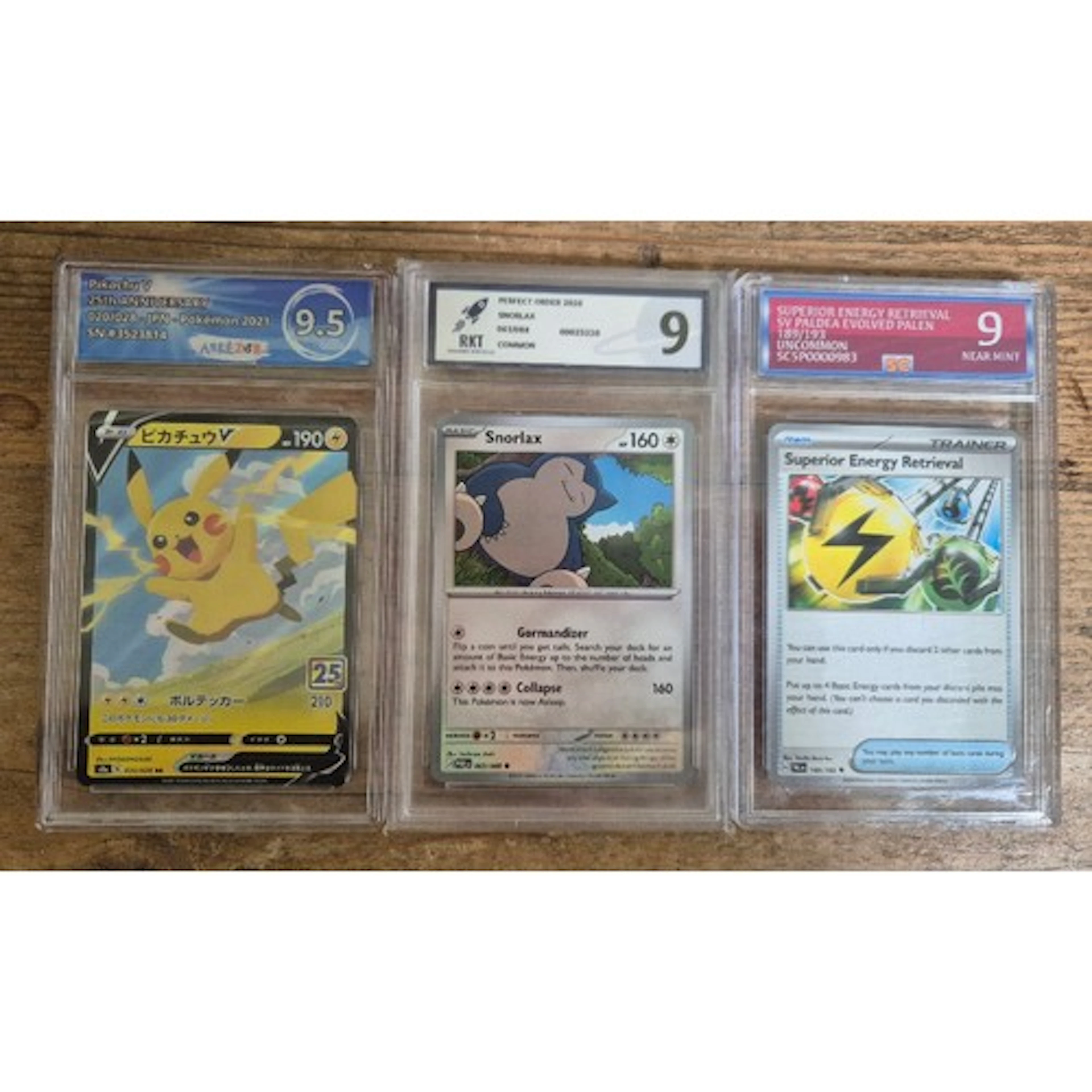 A group of three Pokemon graded cards in plastic slabs compr...