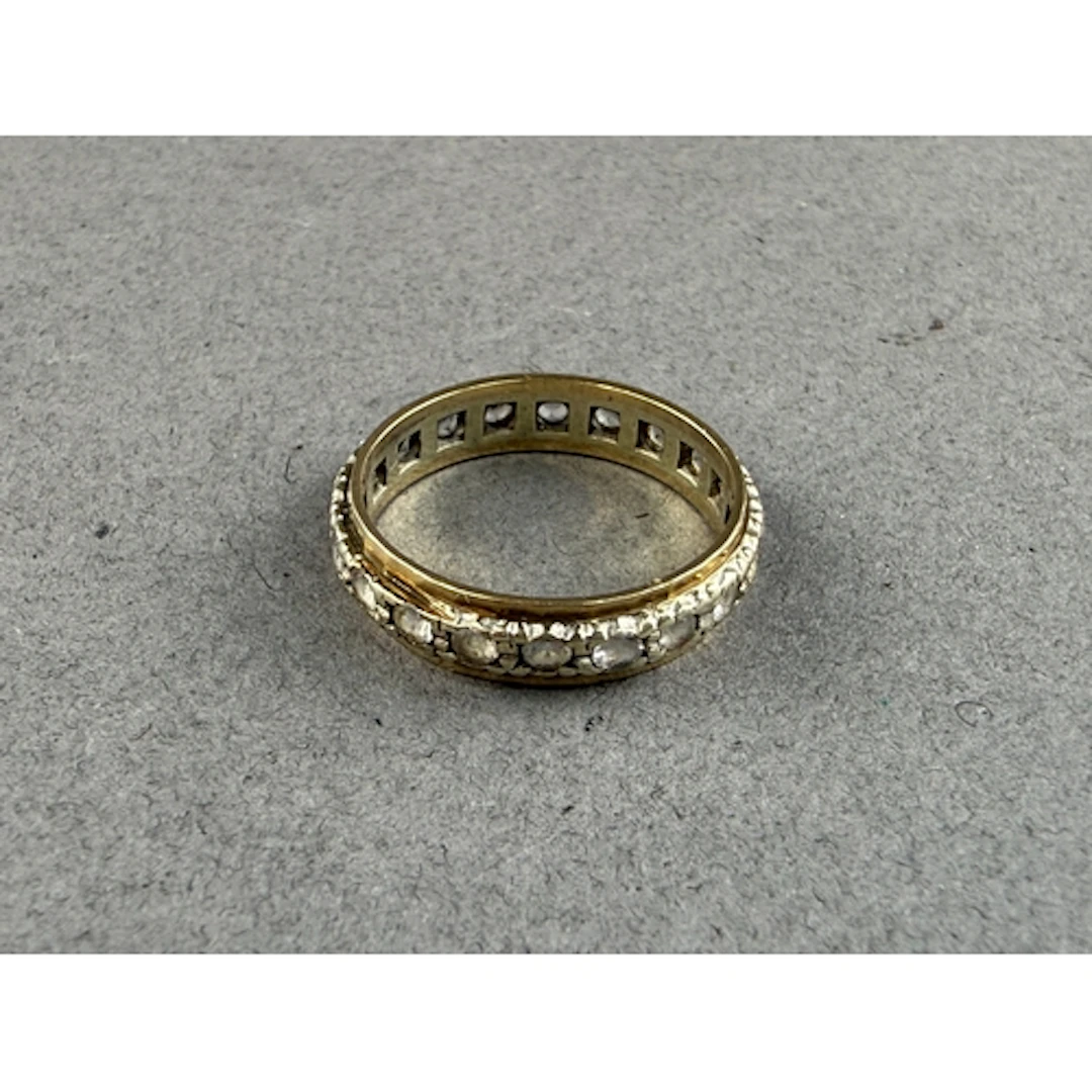 Jewellery: a 9ct gold eternity ring set a row of white paste...