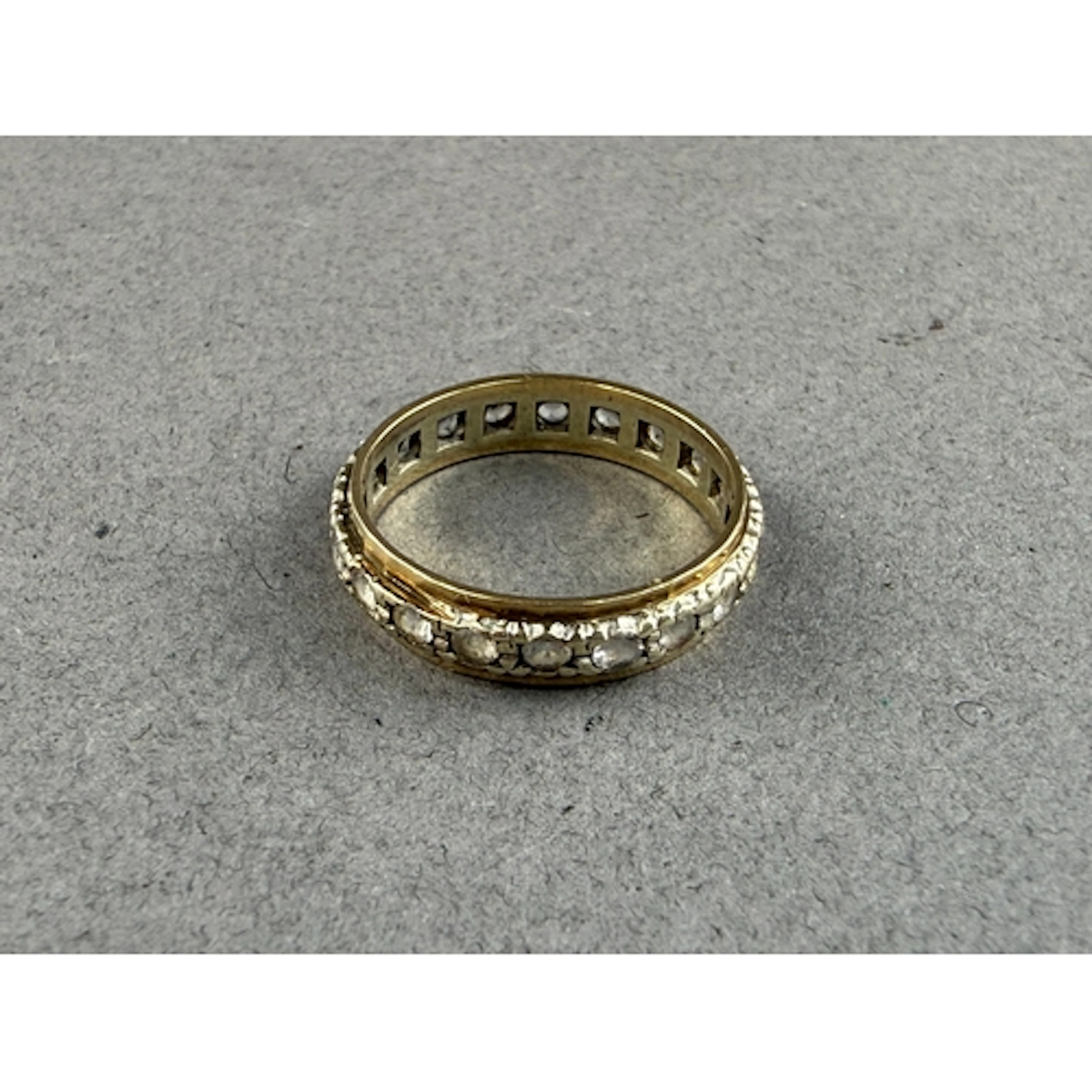 Jewellery: a 9ct gold eternity ring set a row of white paste...