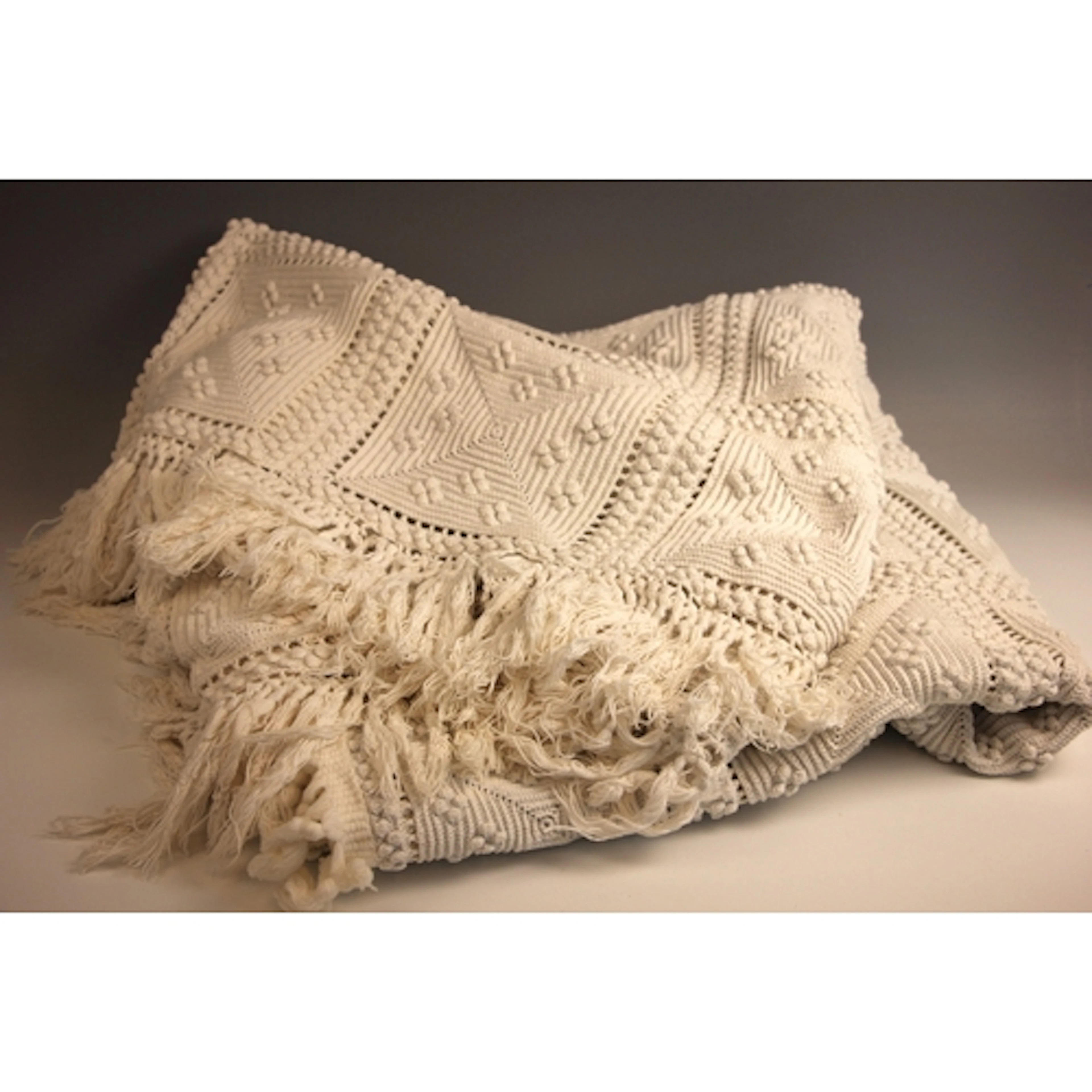 A crocheted cotton bedspread of geometric design with bobble...