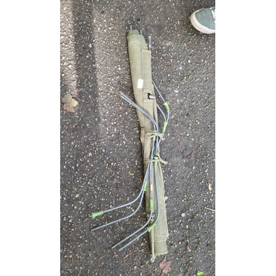 A group of metal tent pegs with angled shafts and green plas...