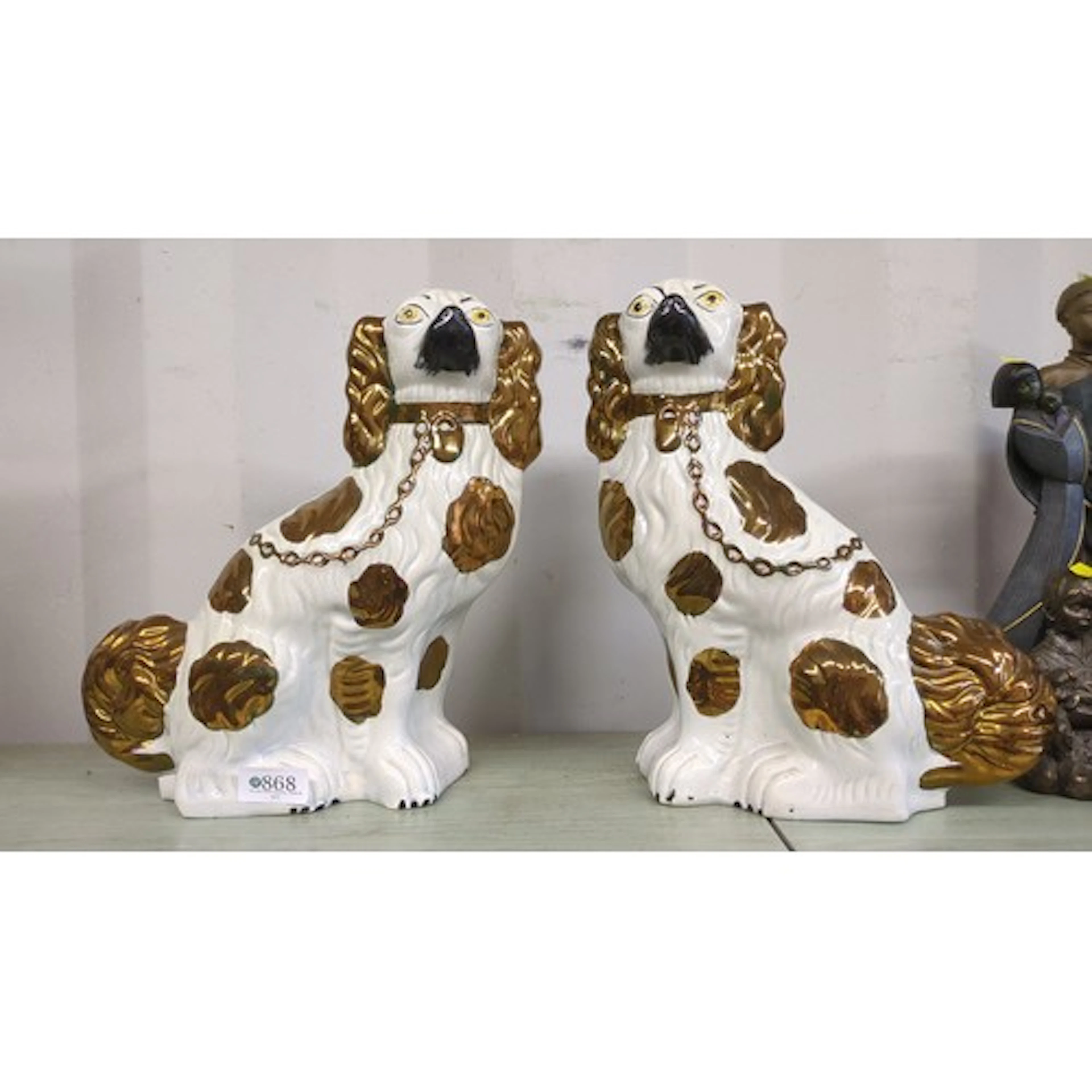 A pair of glazed earthenware spaniel figures, modelled seate...