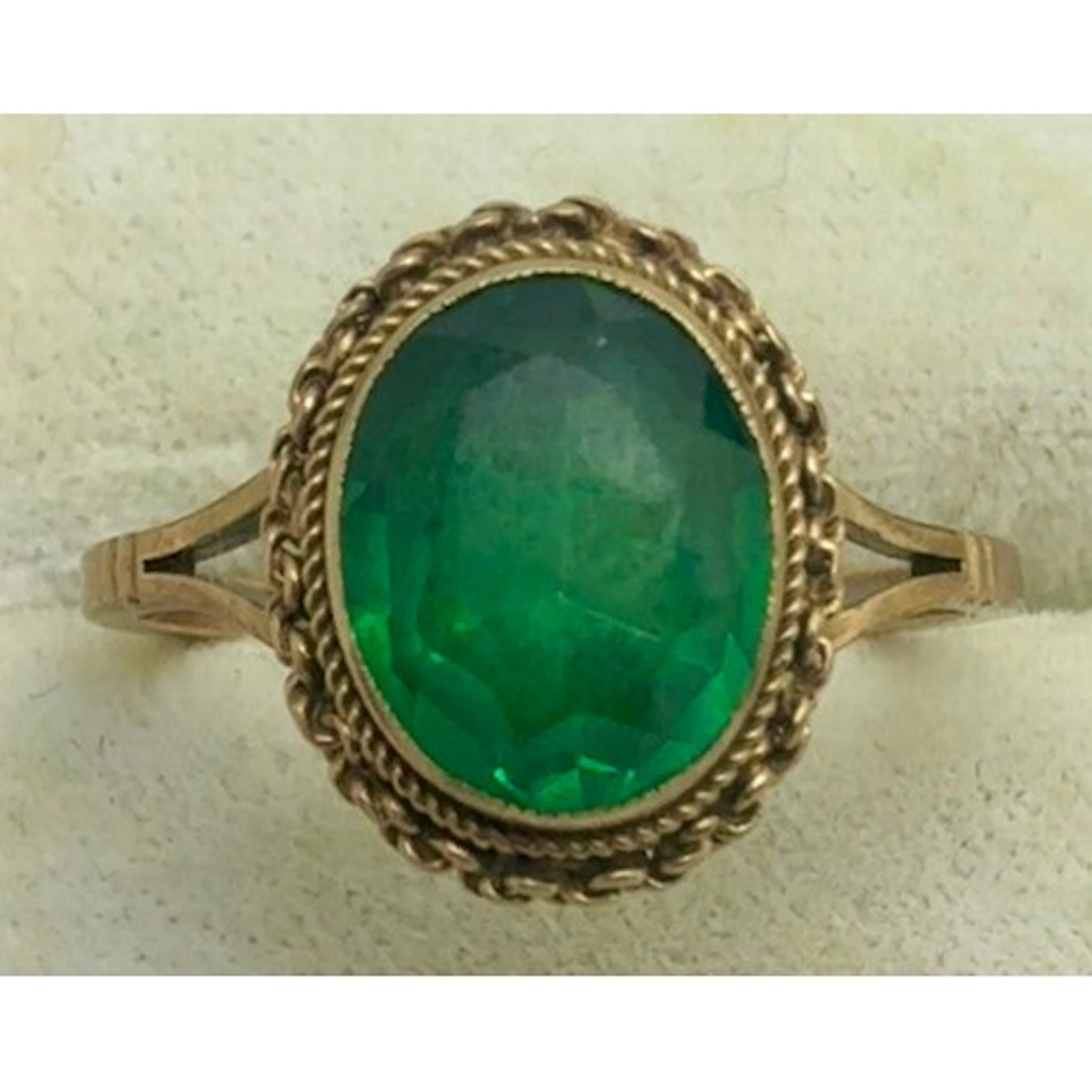 A 9 carat gold ring set with a green stone. Size Q/R. Weight...