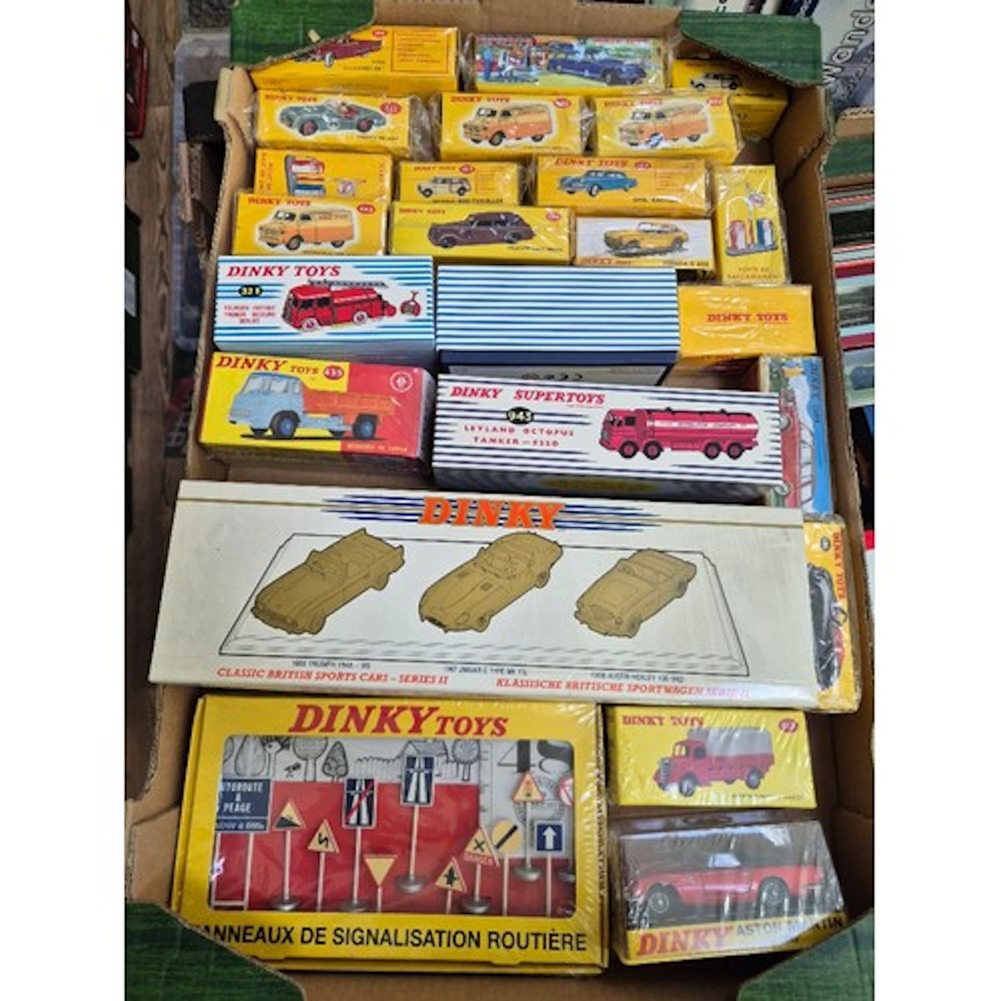 A box of assorted reproduction Dinky diecast vehicles.