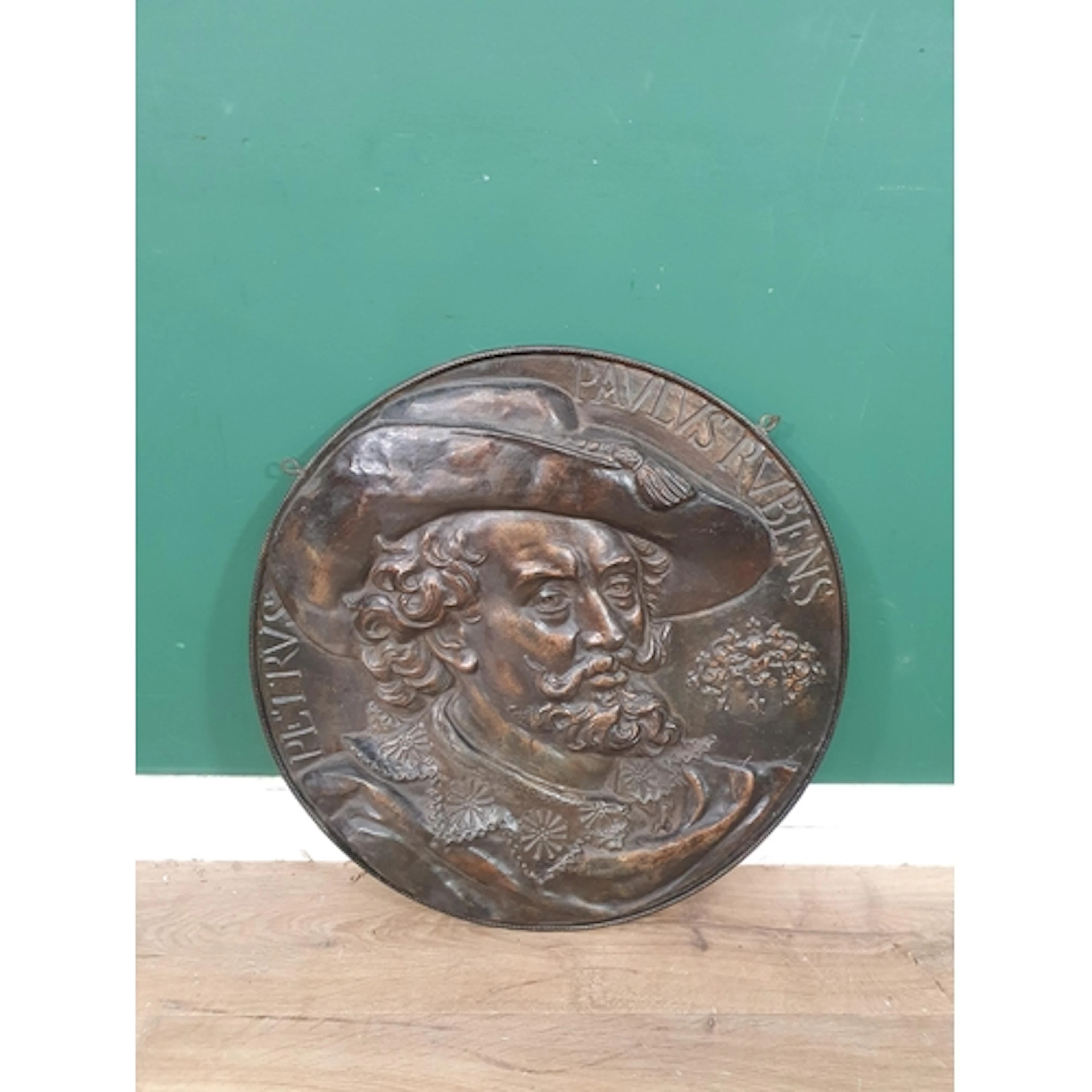 A heavy circular Bronze effect plaque featuring a high-relie...