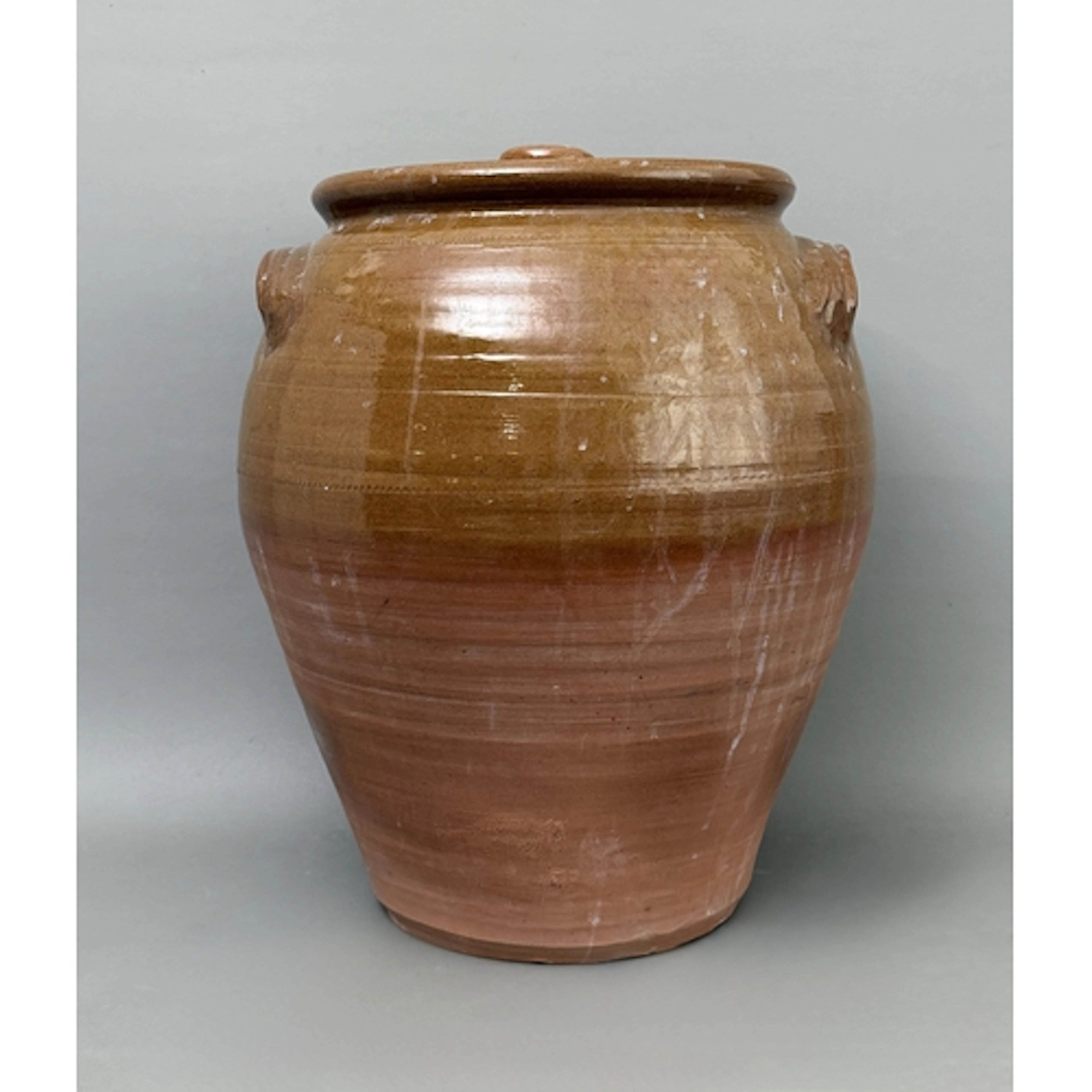A large part glazed terracotta storage jar - with cover and ...