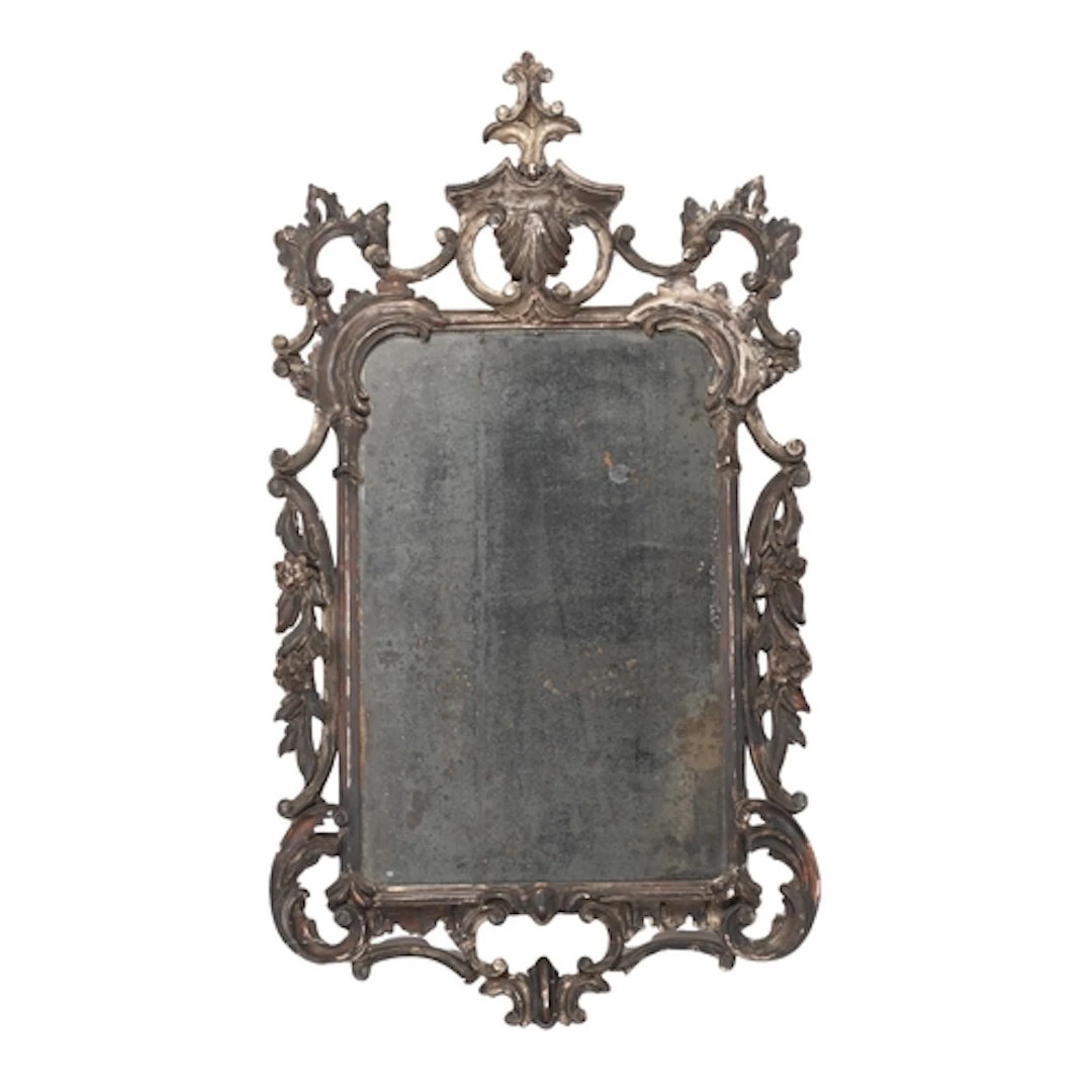 A carved and silvered wood framed rectangular wall mirror in...