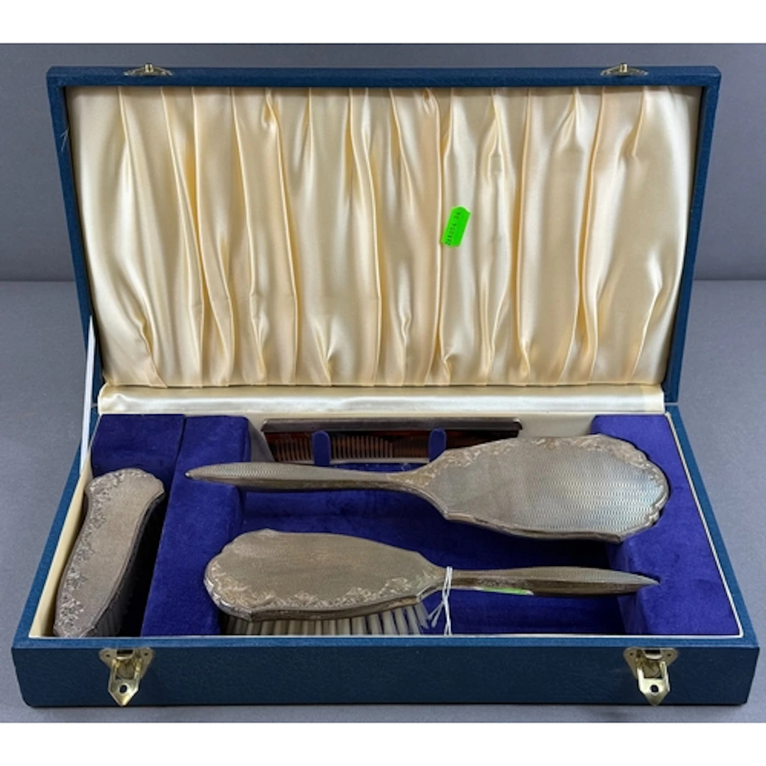 Silver: a four piece dressing table set by Broadway & Co...