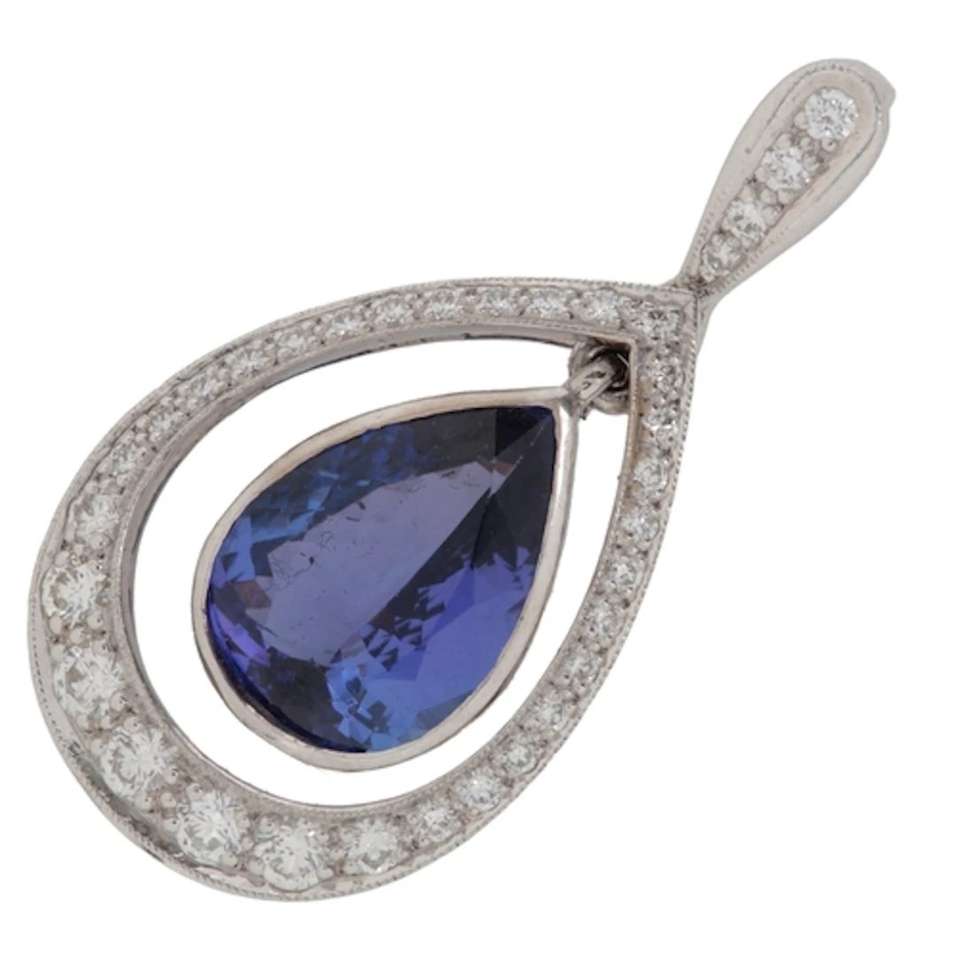 A tanzanite and diamond pendant, collet-set with a pear-shap...