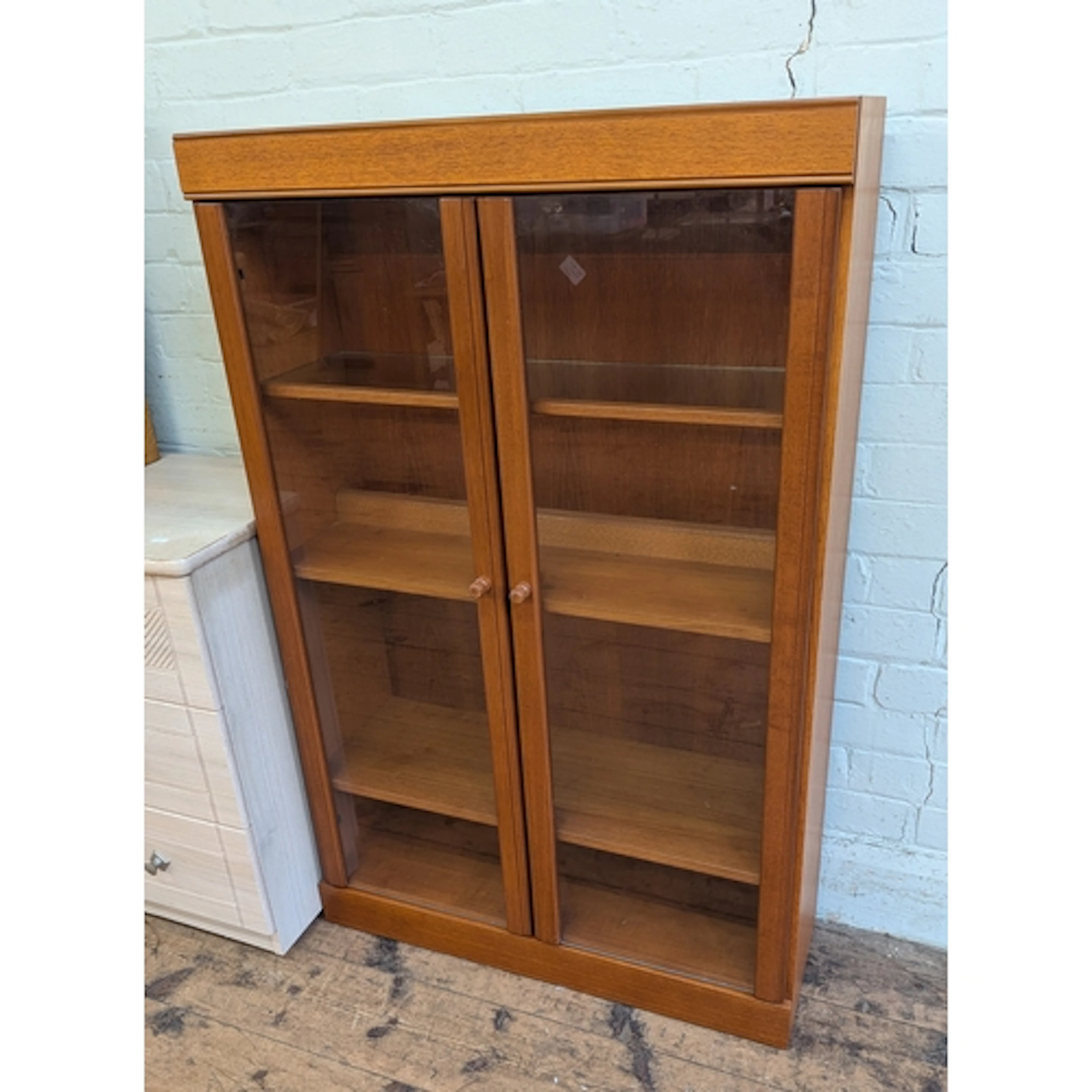 A small modern teak two door glazed bookcase, 2'6" wide