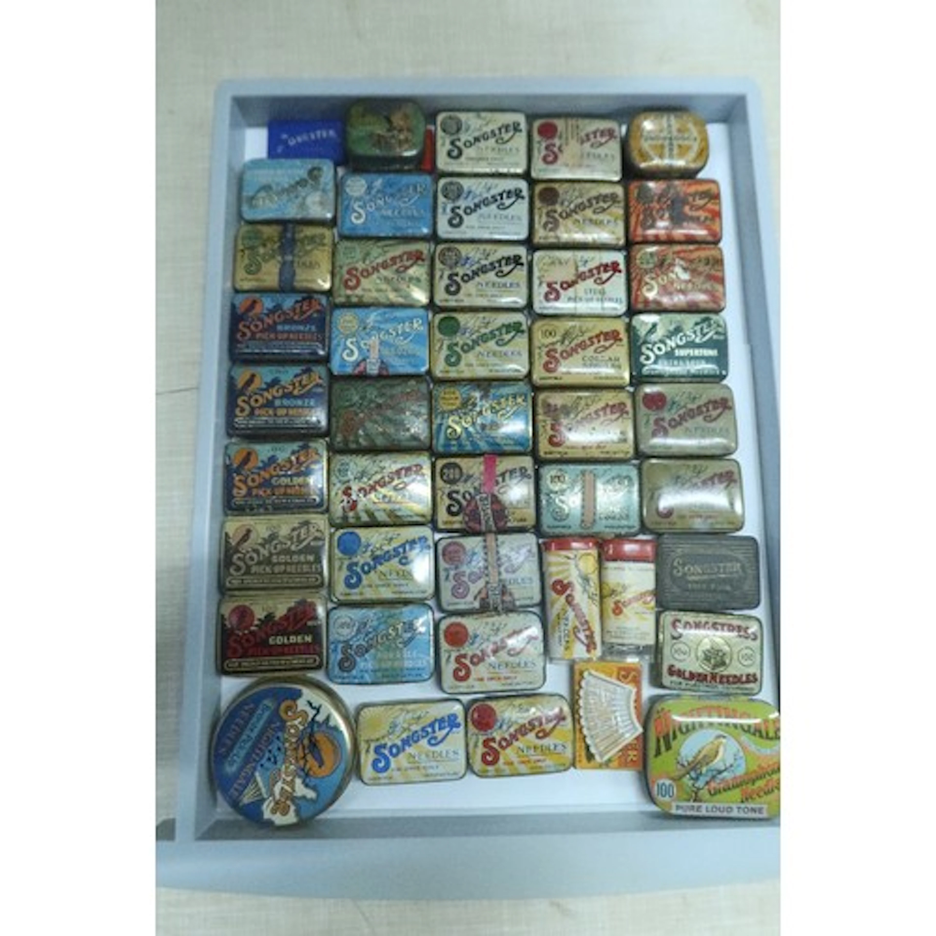 A tray of vintage gramphone needle tins