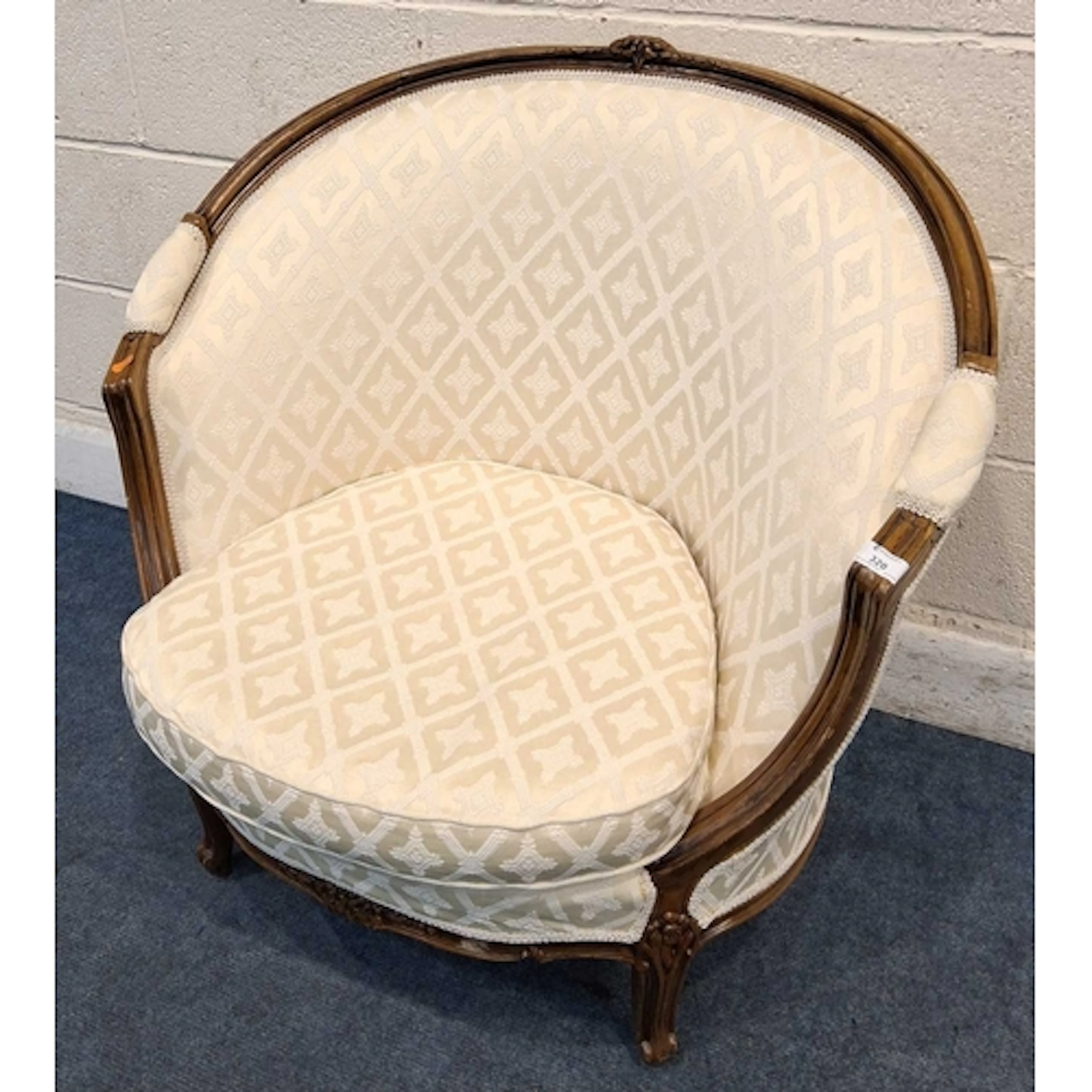 A REPRODUCTION TUB CHAIR, with beige and patterned upholster...