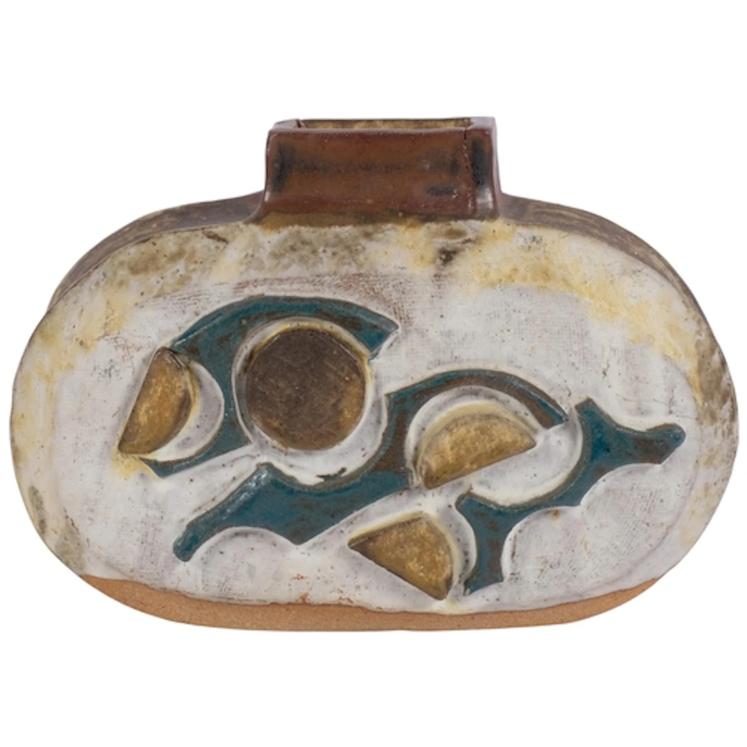 A heavy embossed and painted stoneware vase with abstract de...