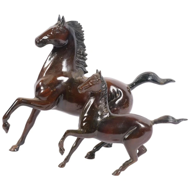 A graduated pair of Chinese cast-metal rearing horses, seal ...