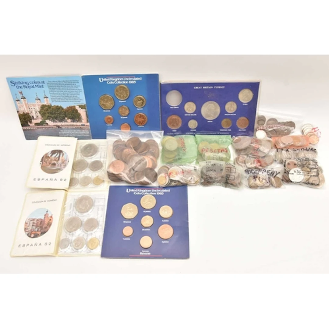 A small collection of coins contained in a sweet box. There ...