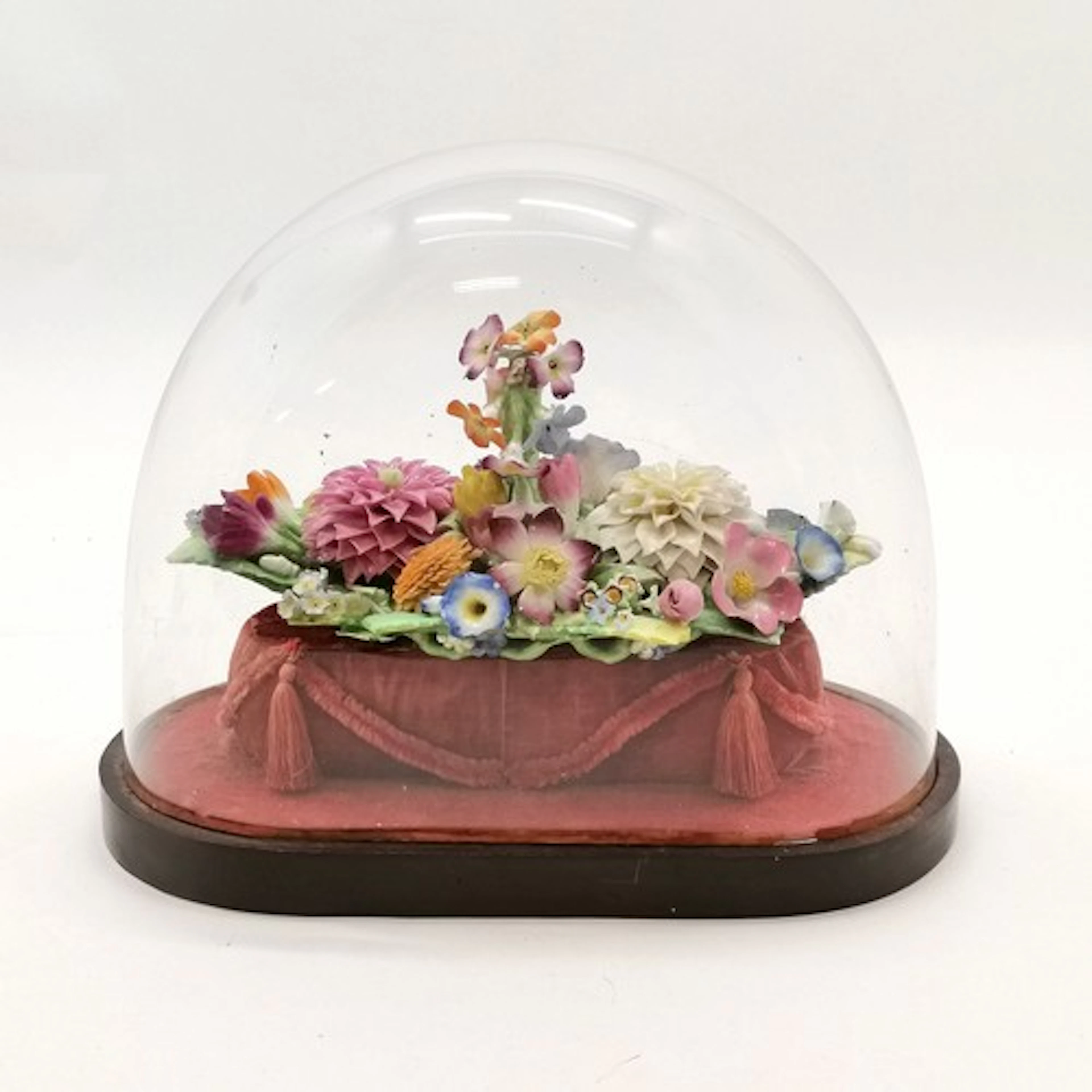 Antique porcelain floral inkwell on a velvet plinth under a ...