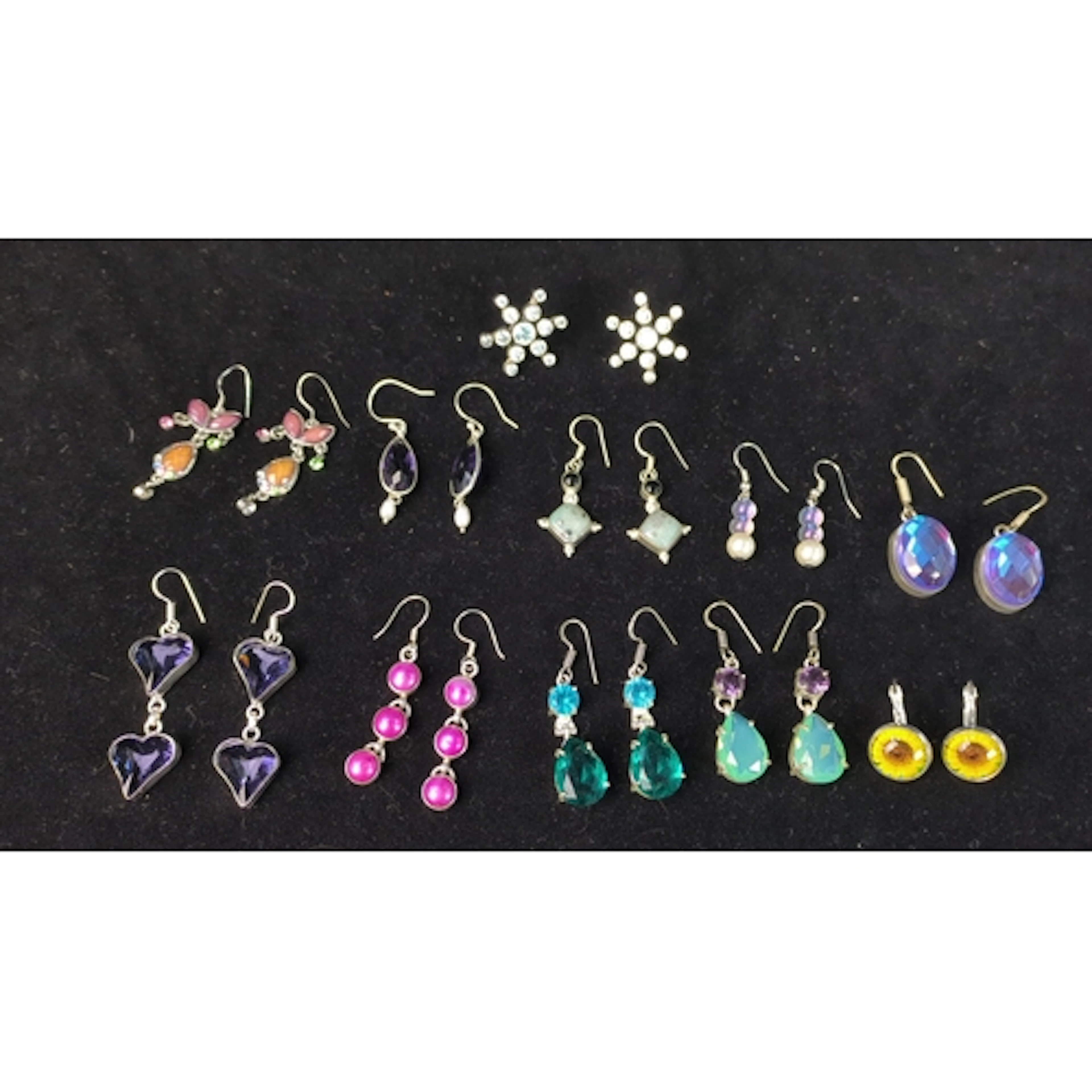 A group of silver-tone earrings, including starburst studs a...