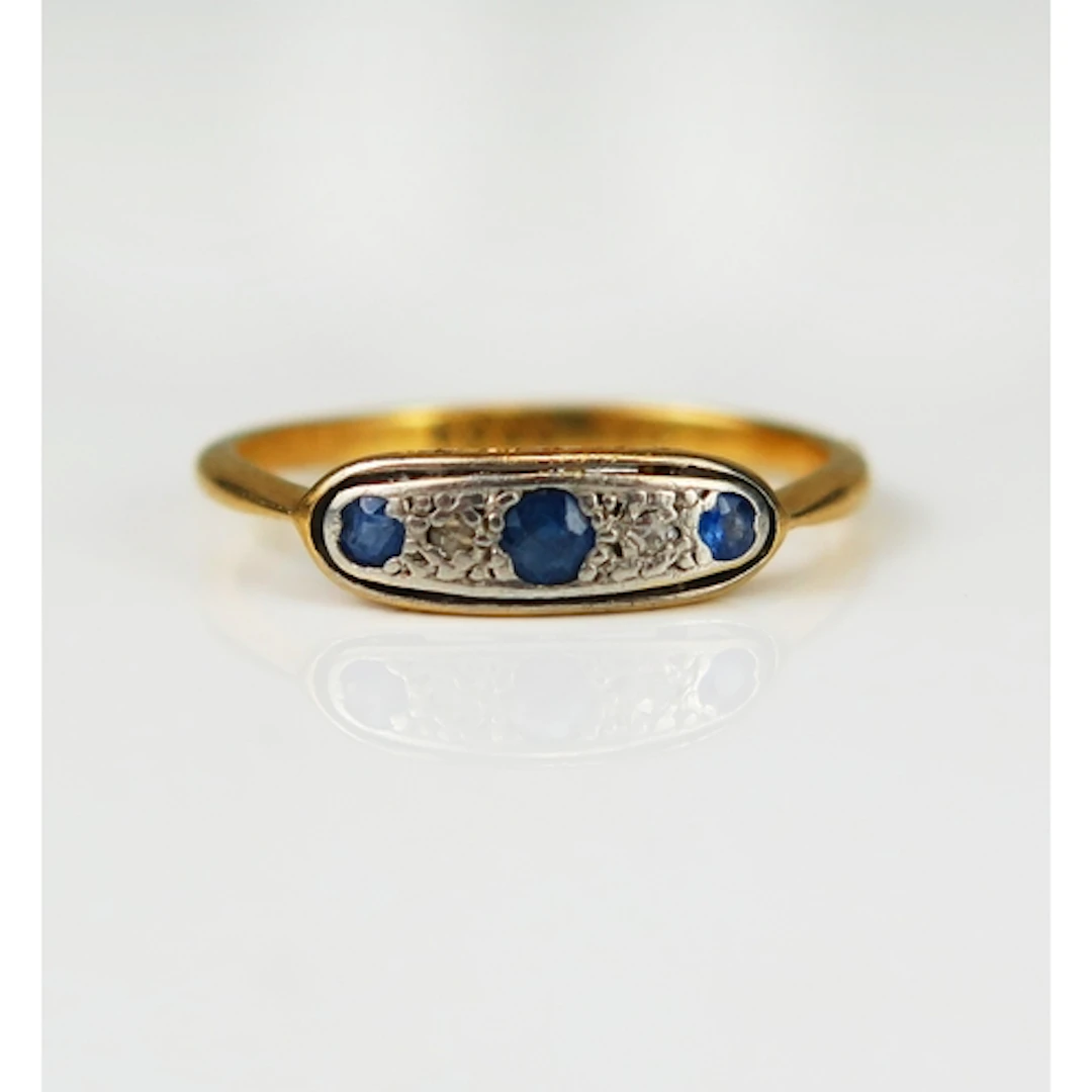 A sapphire and diamond ring in a precious yellow and platinu...