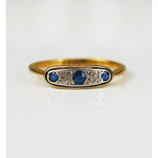 A sapphire and diamond ring in a precious yellow and platinu...