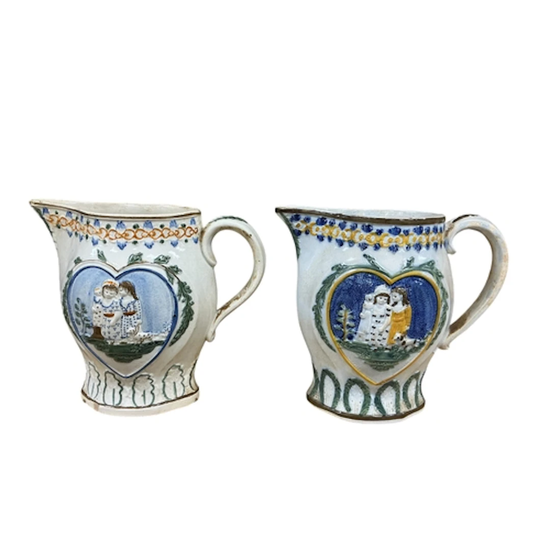 A pair of early 19th century Prattware jugs relief moulded w...