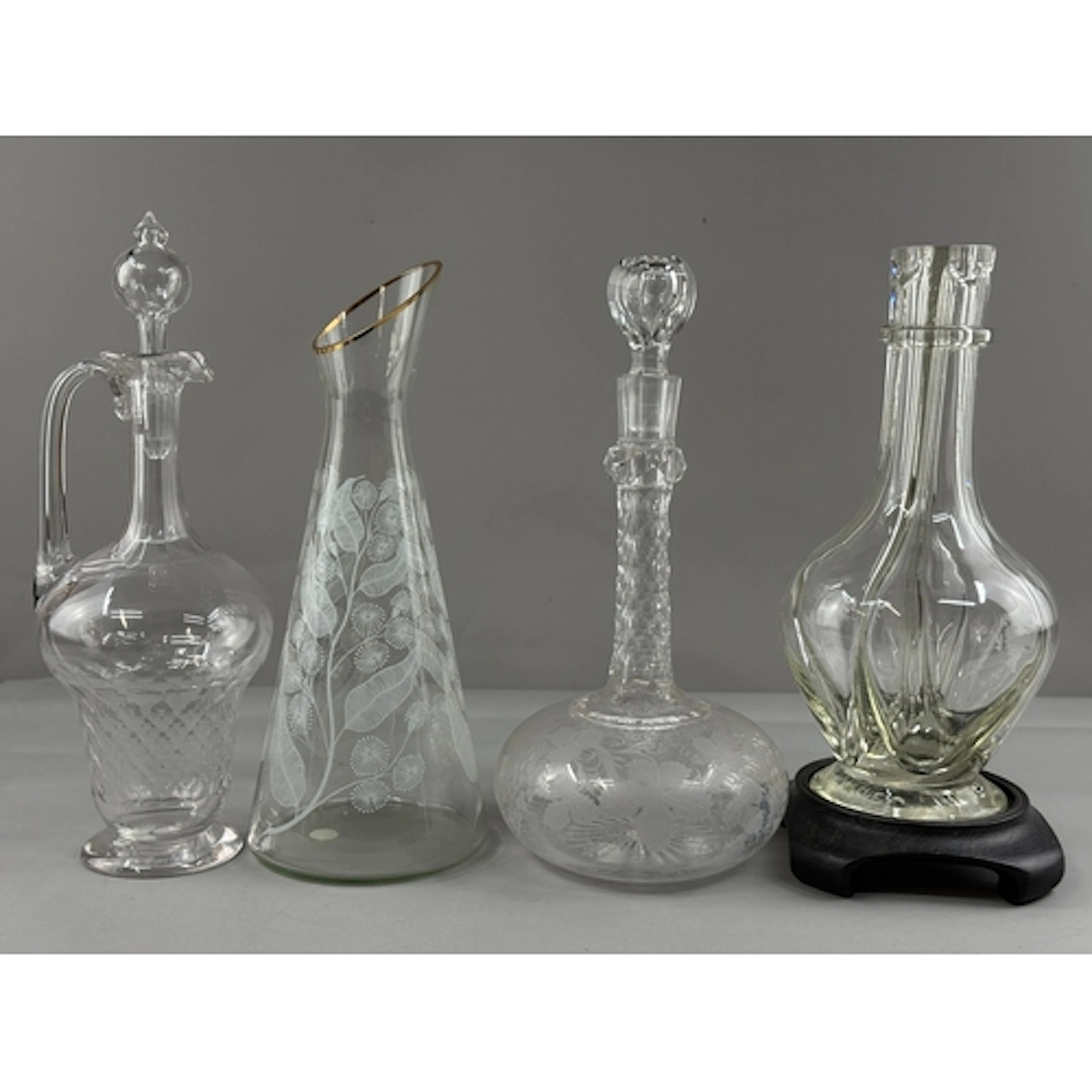 Four glass pouring vessels, 19th century and later, one a co...