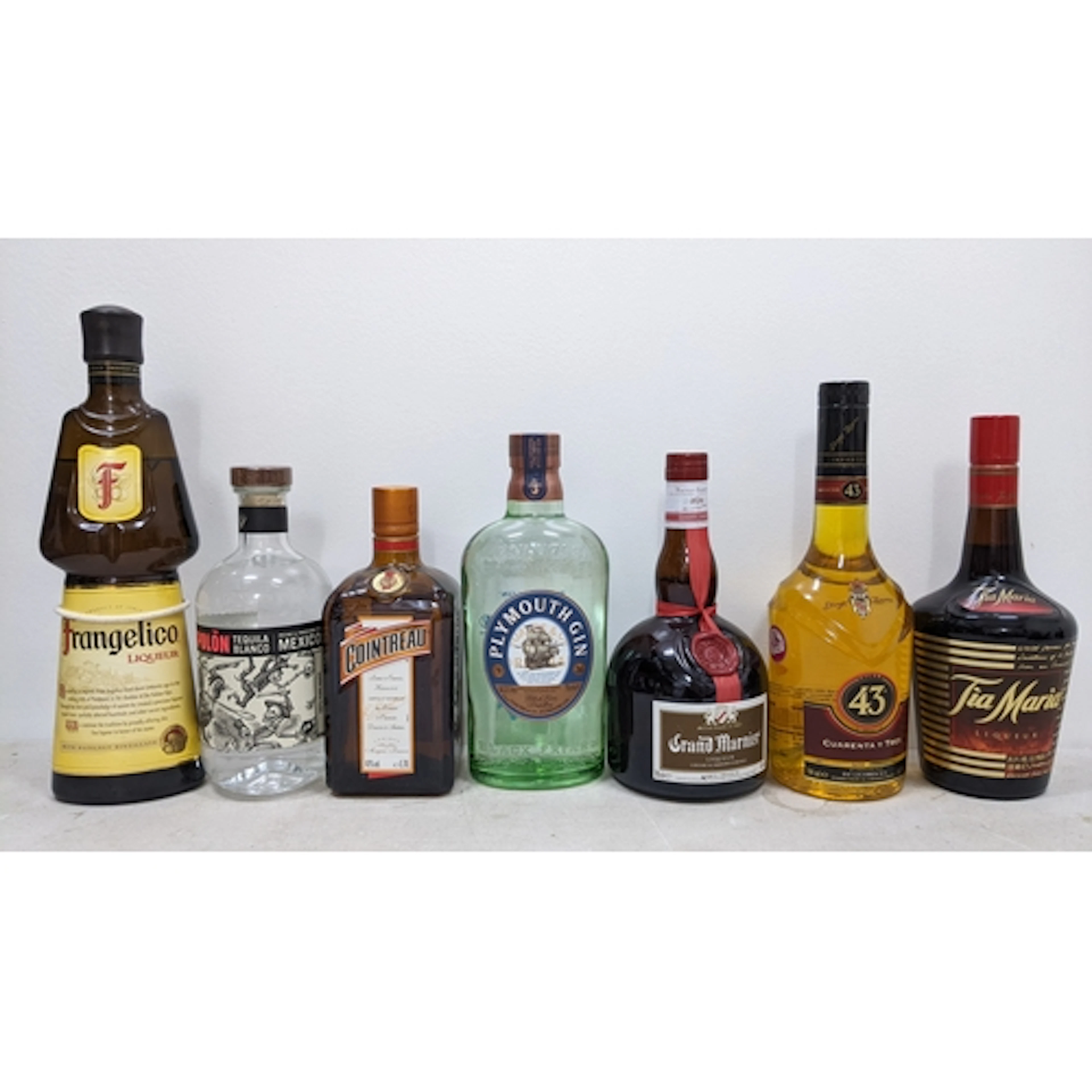 Seven bottles of assorted spirits and liqueurs and a mixing ...