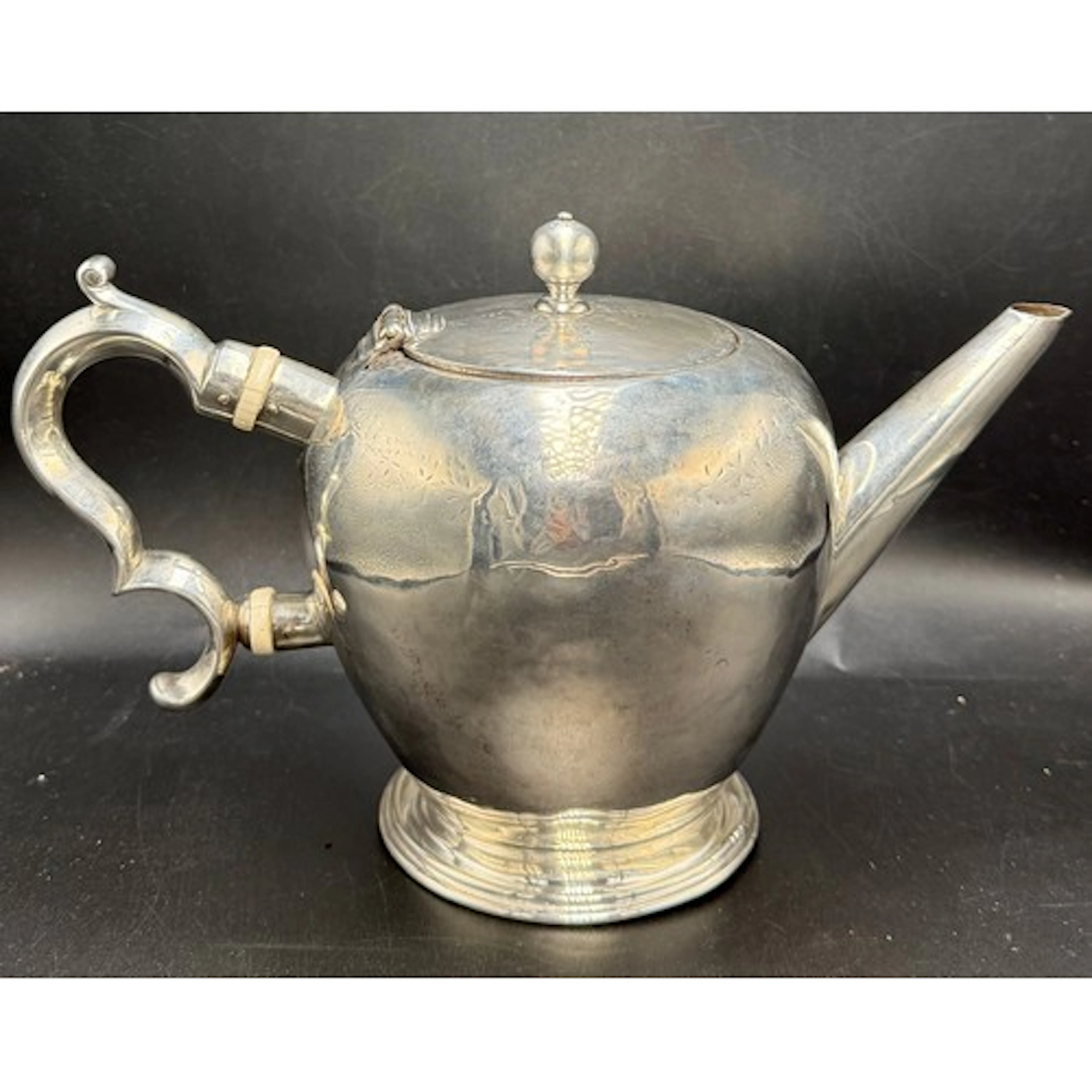 A bullet shaped silver teapot with double C scroll handle an...
