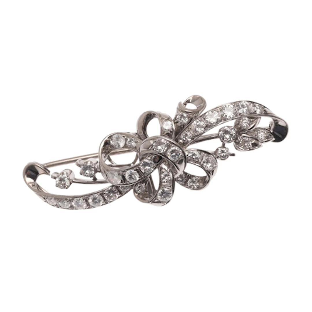 A DIAMOND BROOCH. of foliate and ribbon design, set througho...