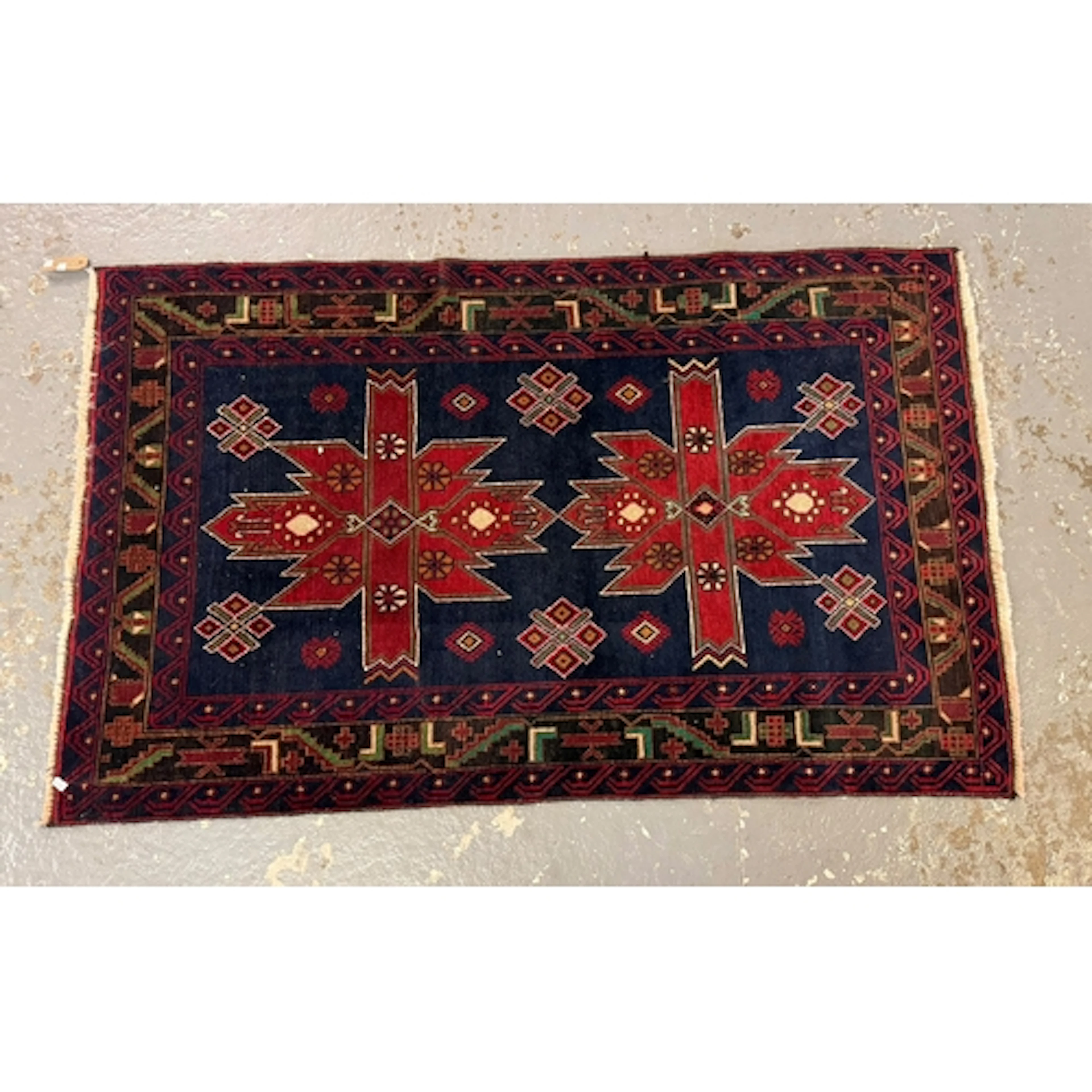 Two similar Pakistan hand knotted woolen rugs, both on a red...