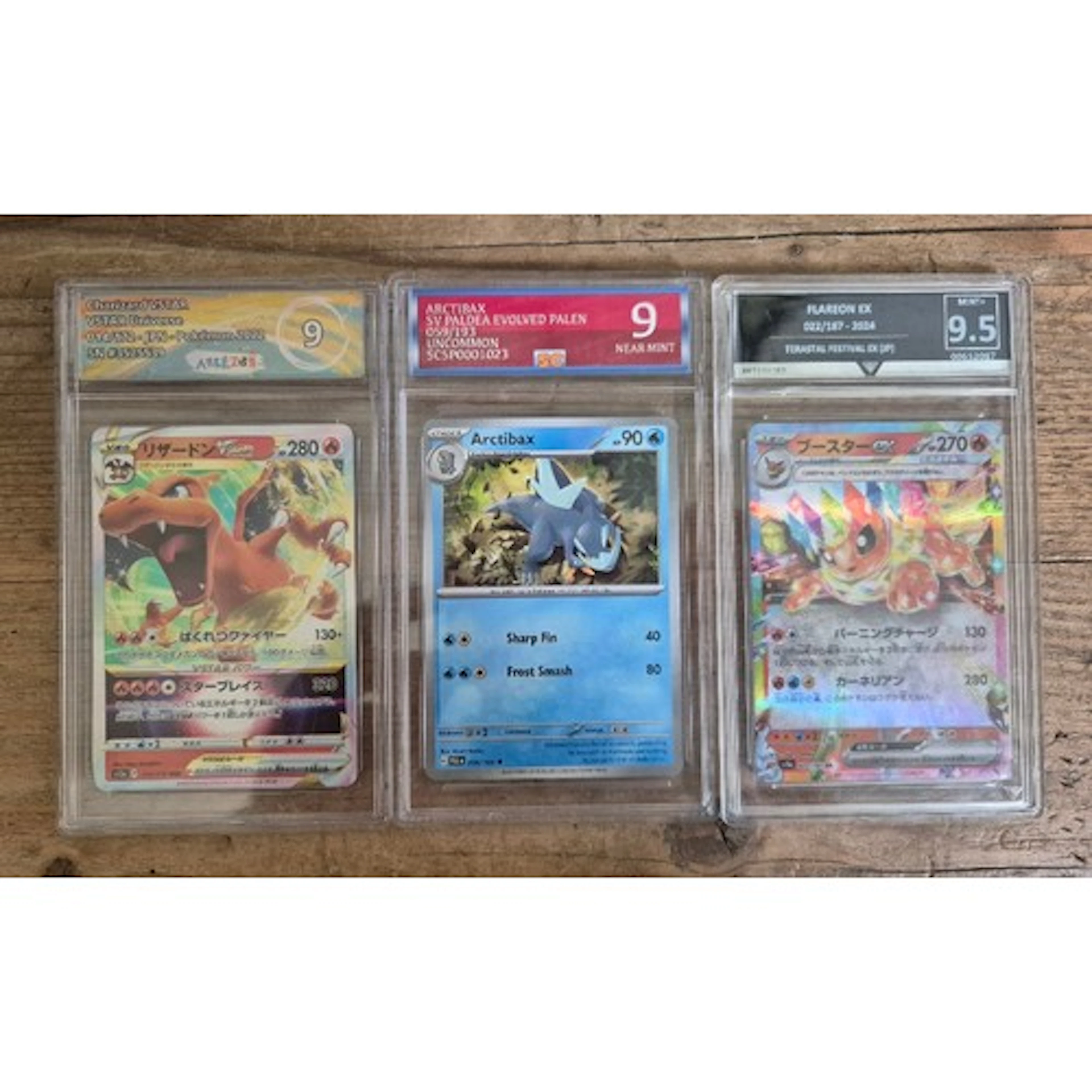 A group of three Pokemon graded cards in plastic slabs compr...