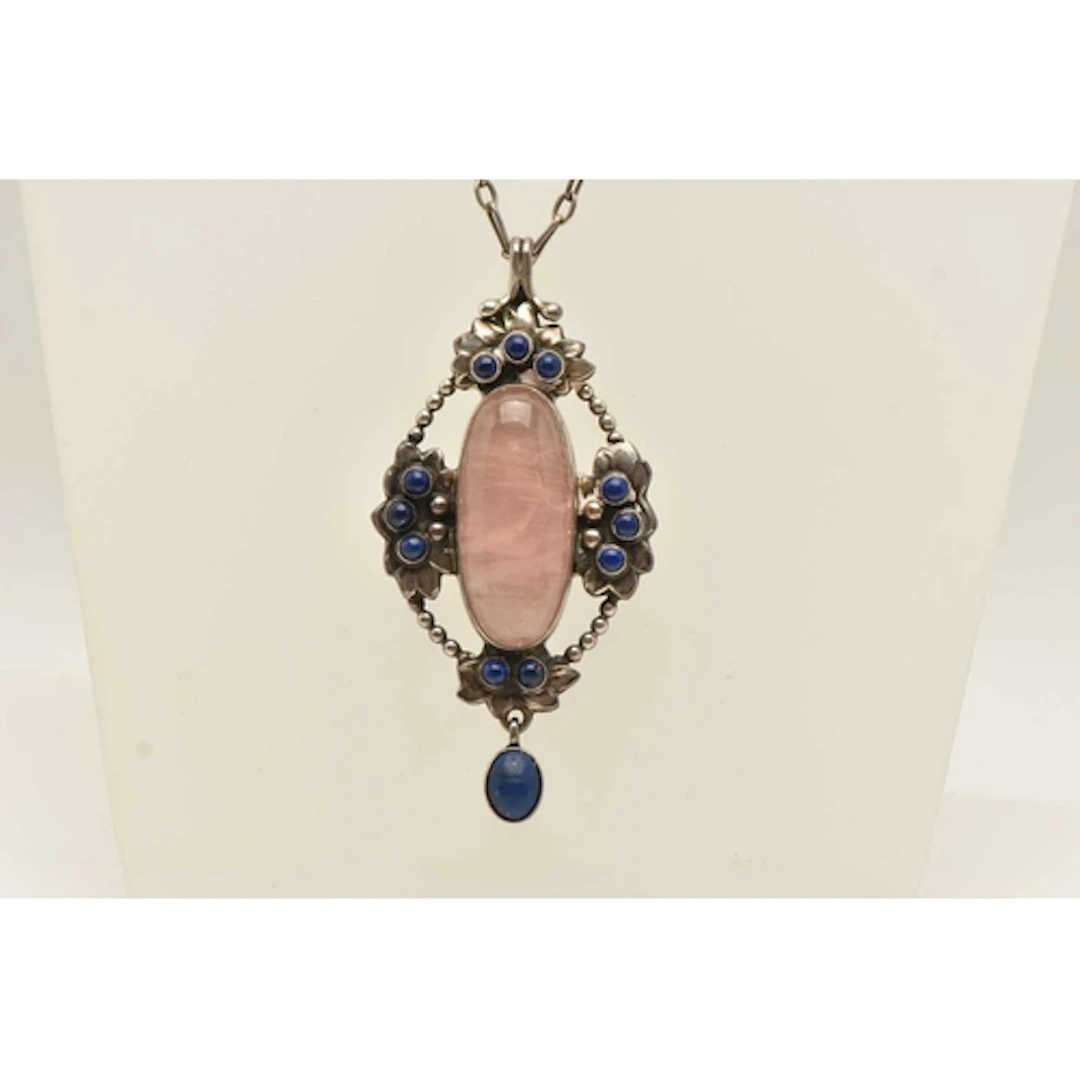 A GEORG JENSEN PENDANT, circa 1910 - 1925, a white metal ova...
