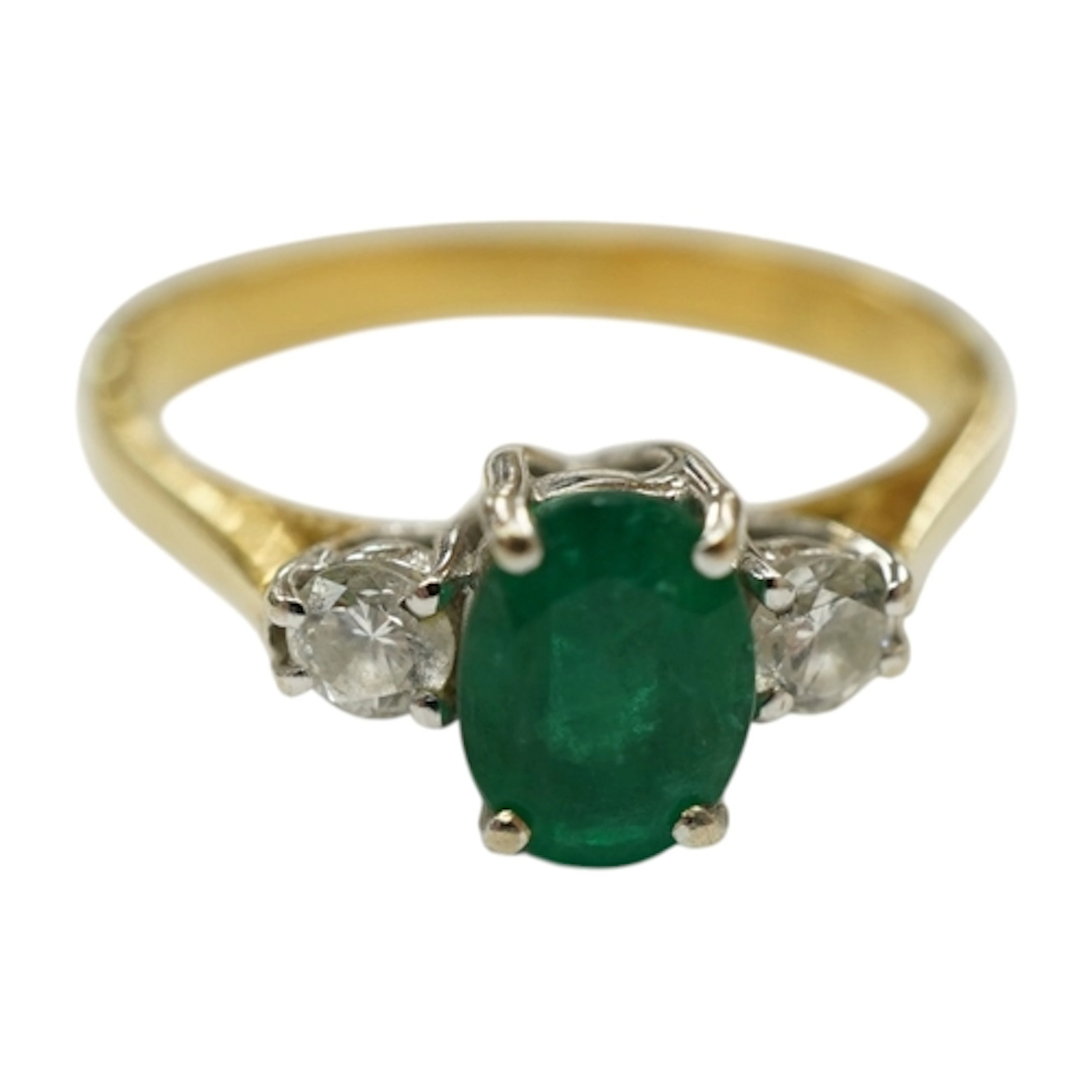 A modern 18ct gold emerald and diamond three stone ring, siz...