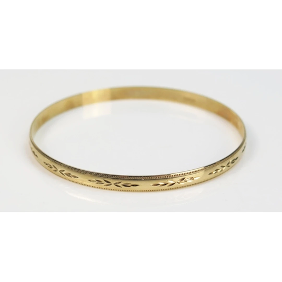A 9ct gold bangle with chased decoration, c. 21cm circumfere...