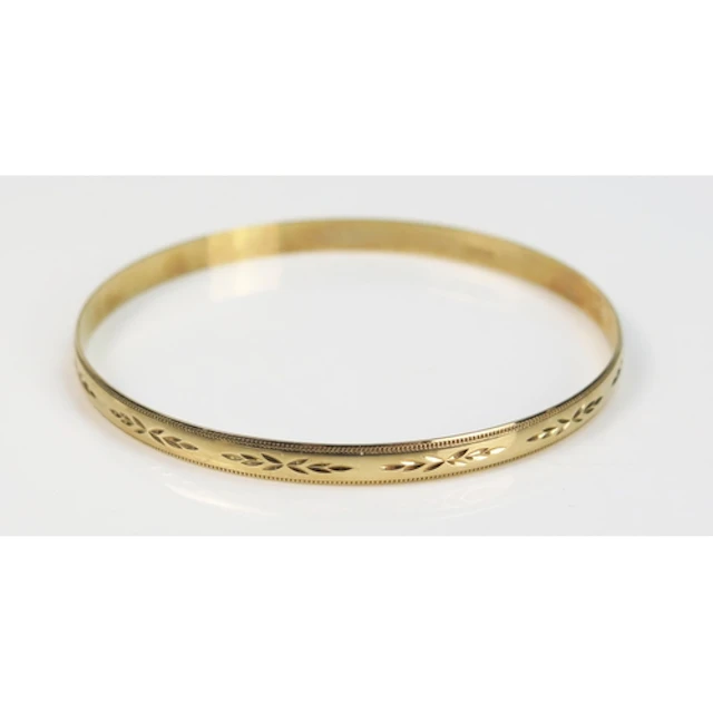 A 9ct gold bangle with chased decoration, c. 21cm circumfere...