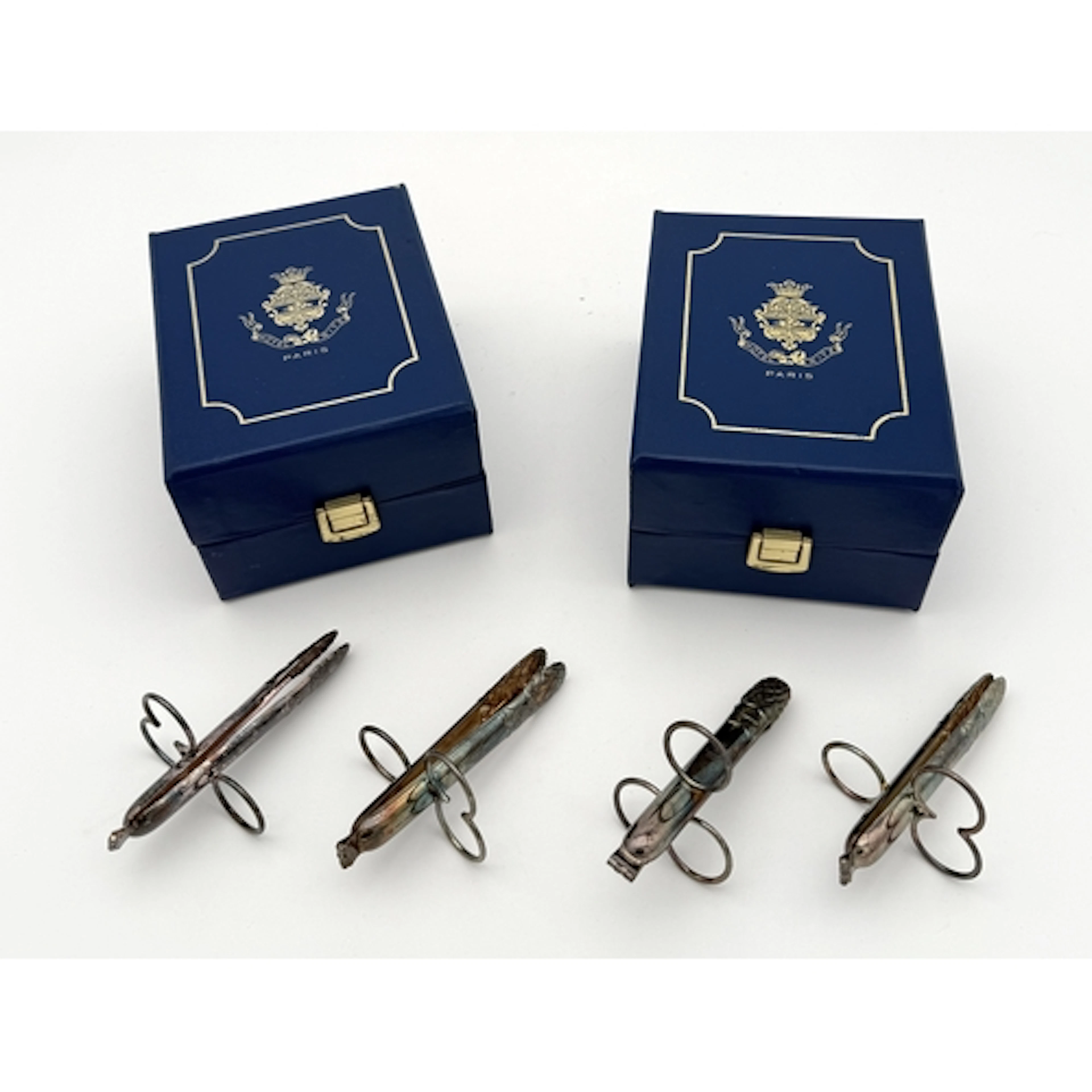 TWO PAIRS OF CHRISTOFLE SILVER PLATED HOLDERS In original bo...