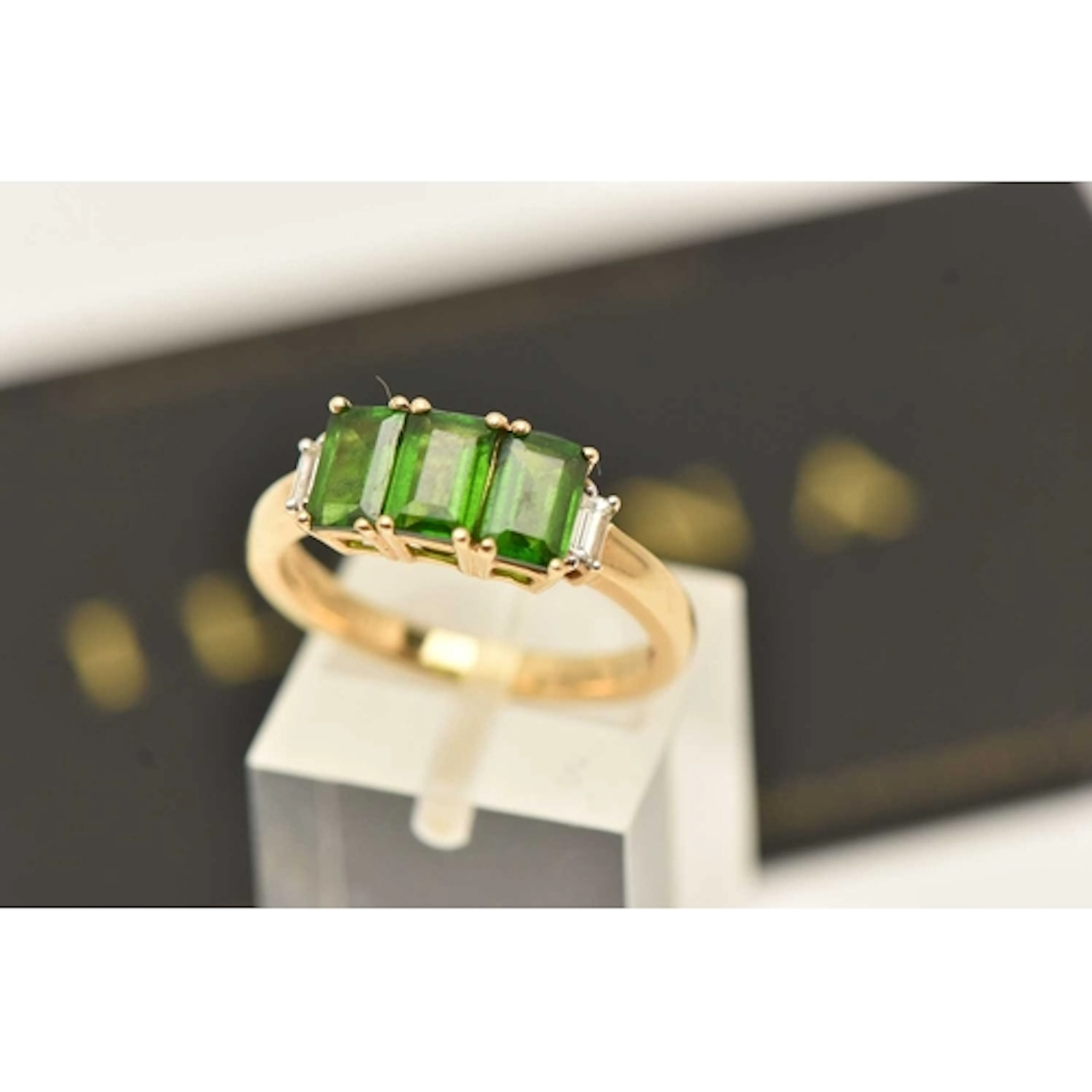 AN 18CT YELLOW GOLD GEM SET RING, a three rectangular cut di...