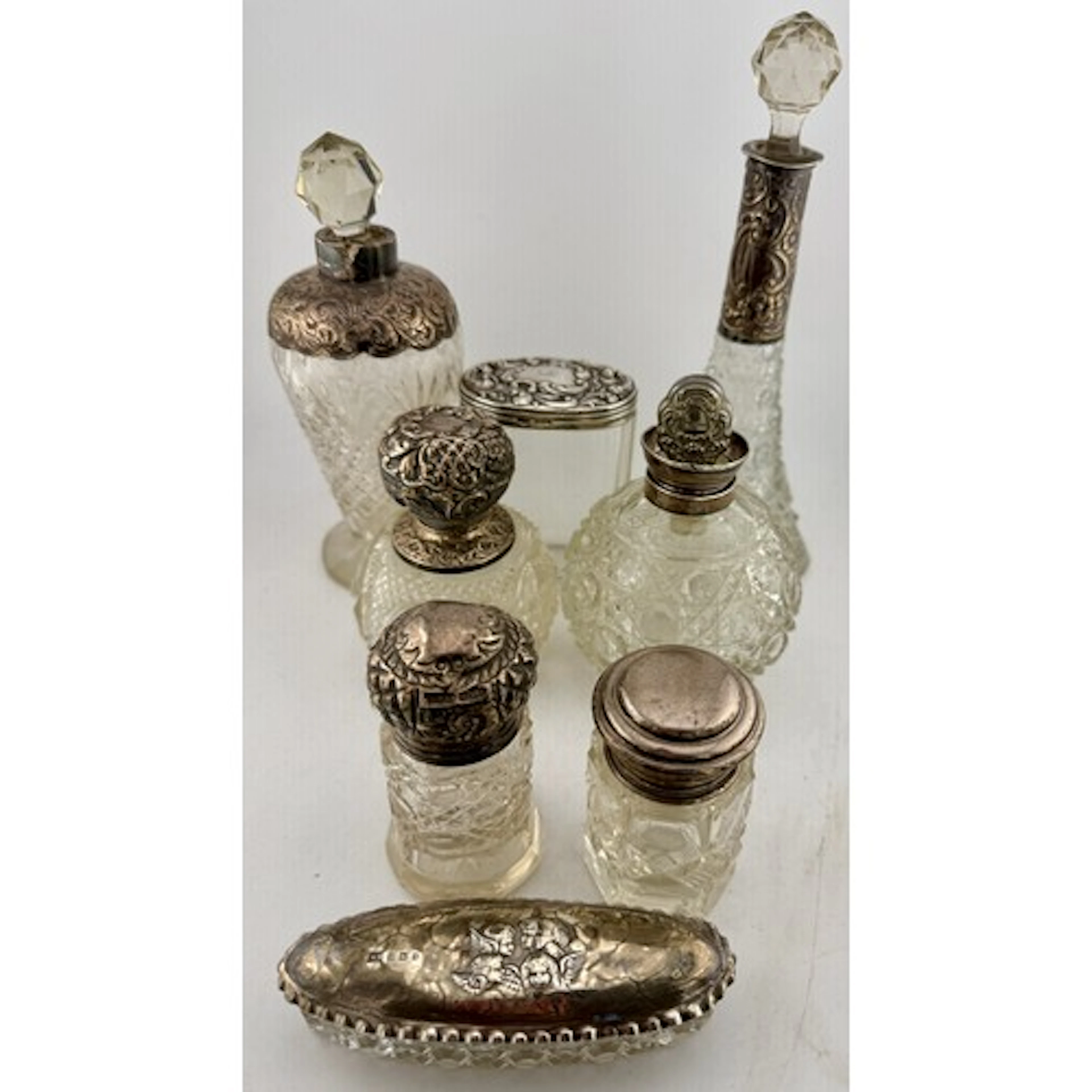 Eight silver topped glass dressing table jars. Various dates...