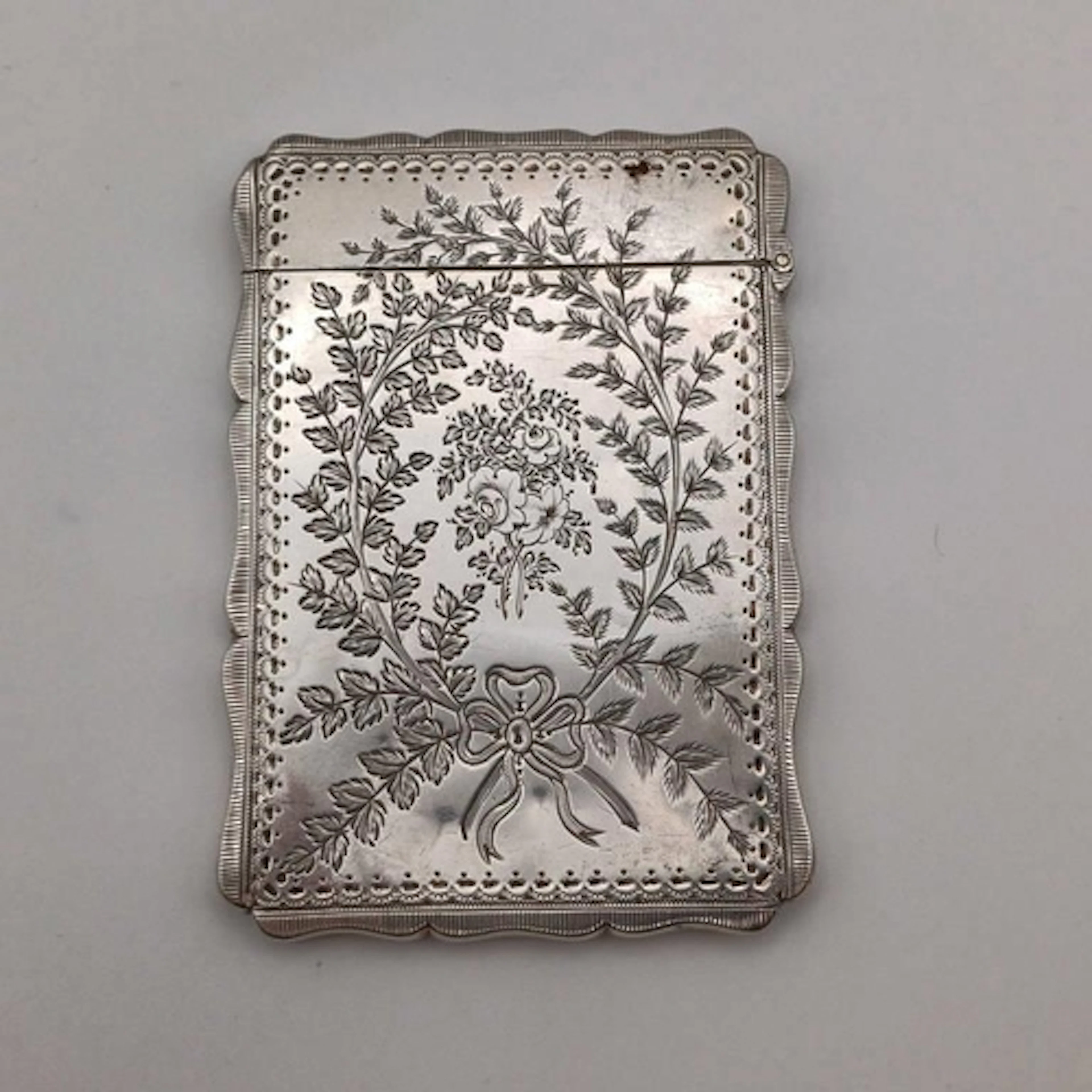 A VICTORIAN SILVER CARD CASE WITH ENGRAVED FOLIATE DECORATIO...