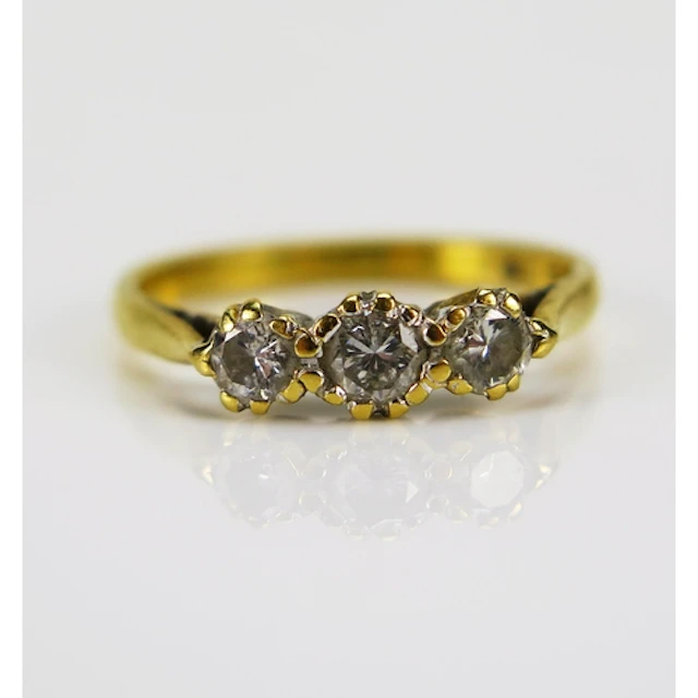 A three stone diamond ring in an 18ct yellow gold setting, s...