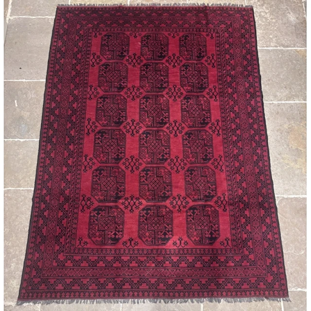 A large full pile Afghan Bokhara wool rug, with a traditiona...