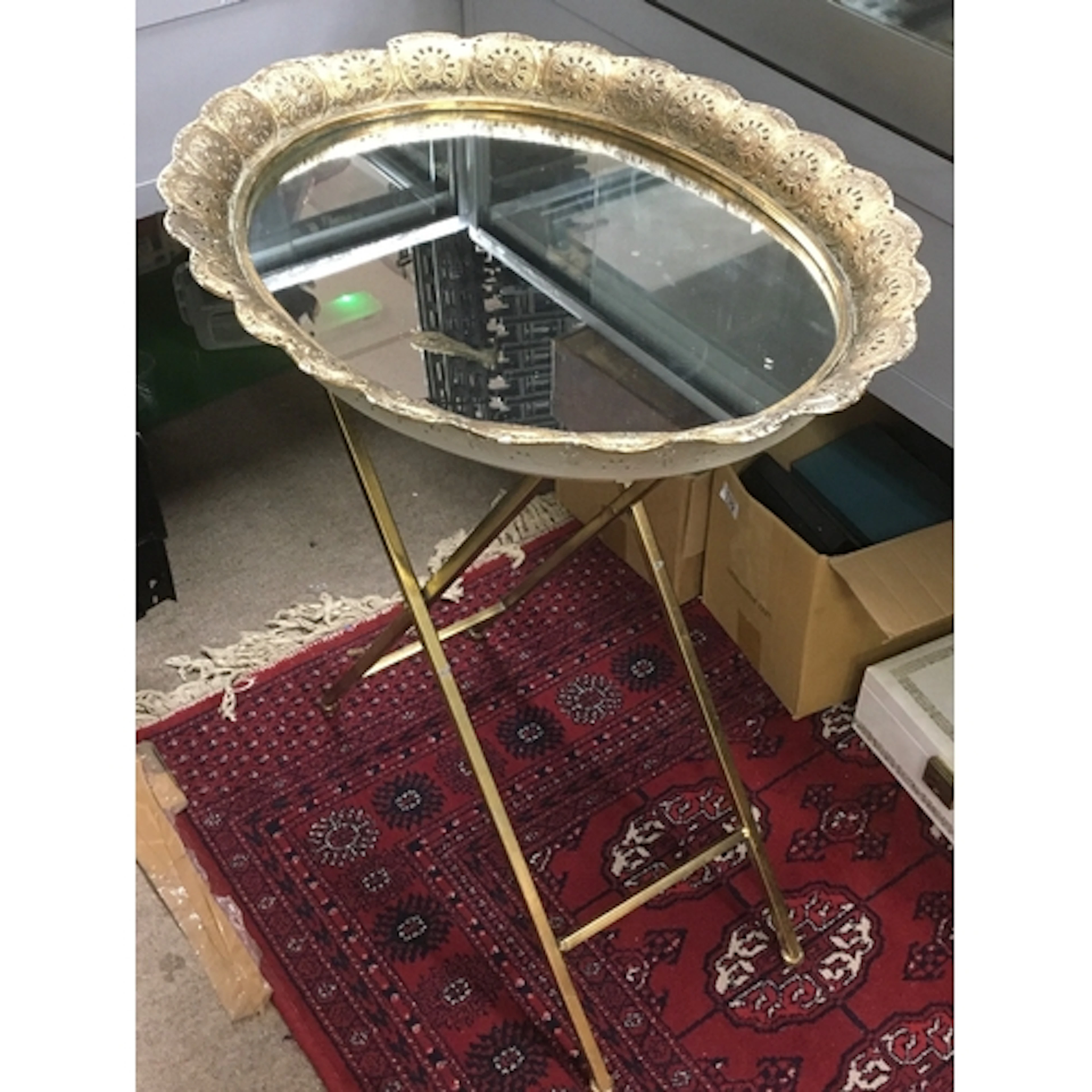 Moroccan brass tray table featuring a folding metal base and...