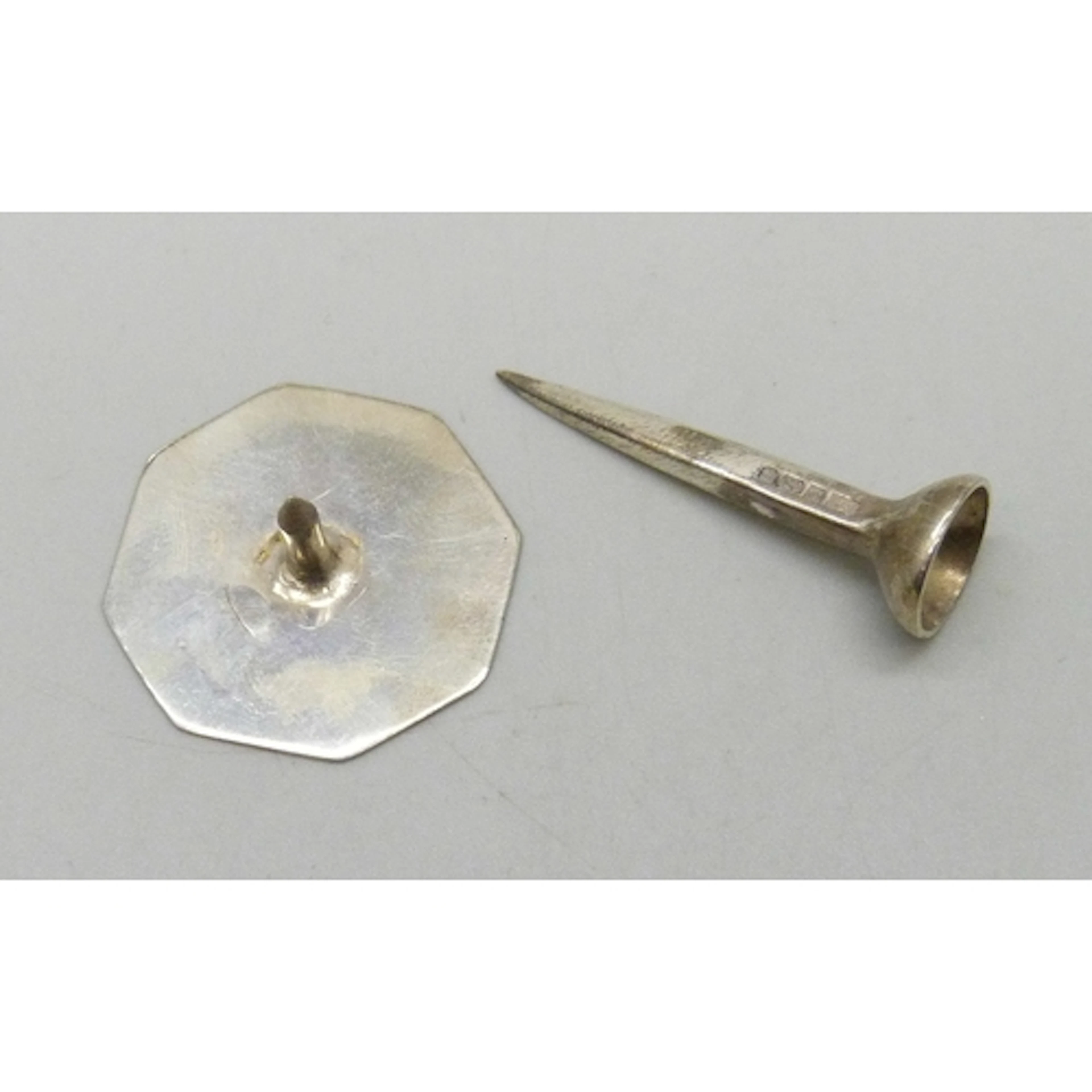 A silver golf tee and a silver golf marker, 7.6g total