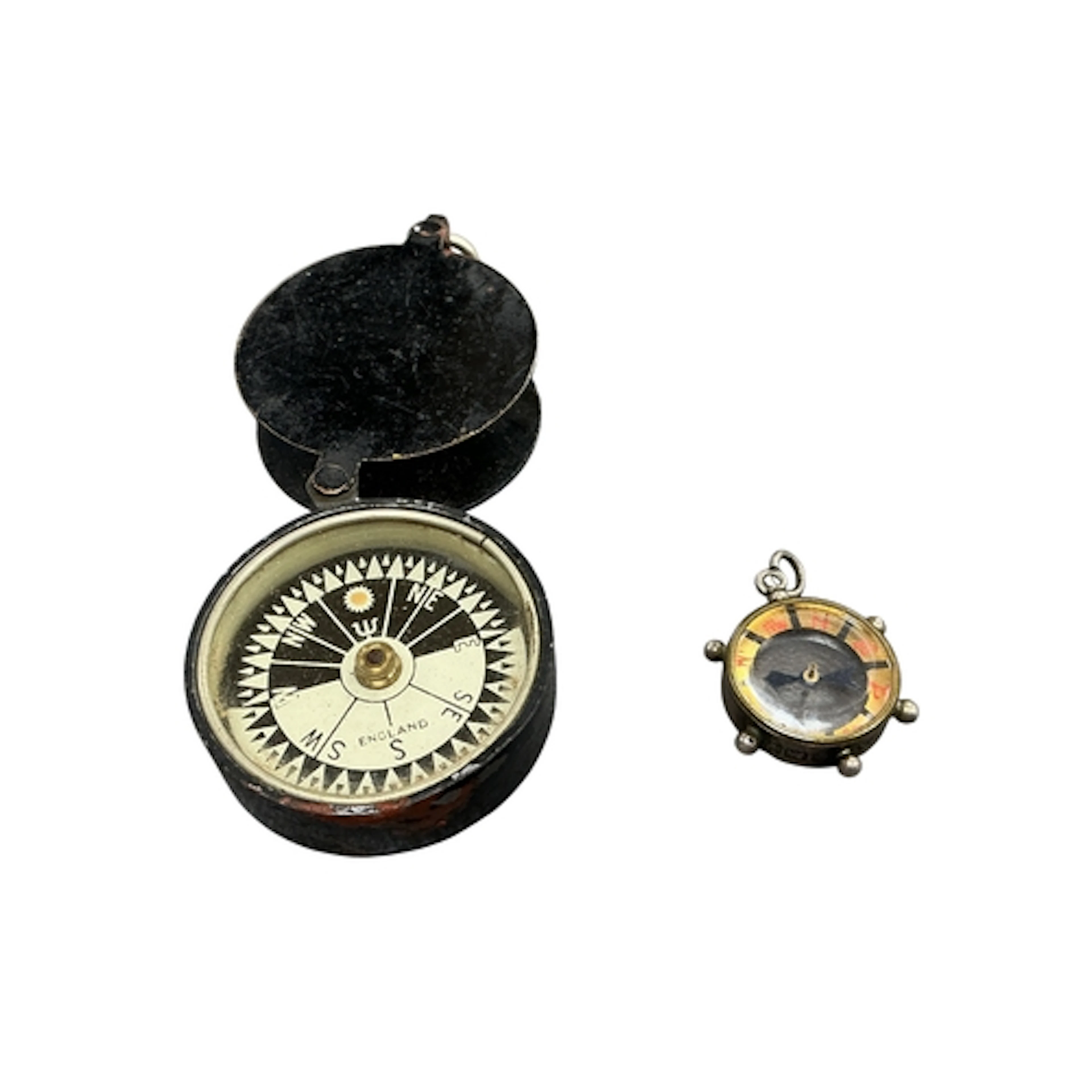 A miniature silver compass and brass folding pocket compass,...