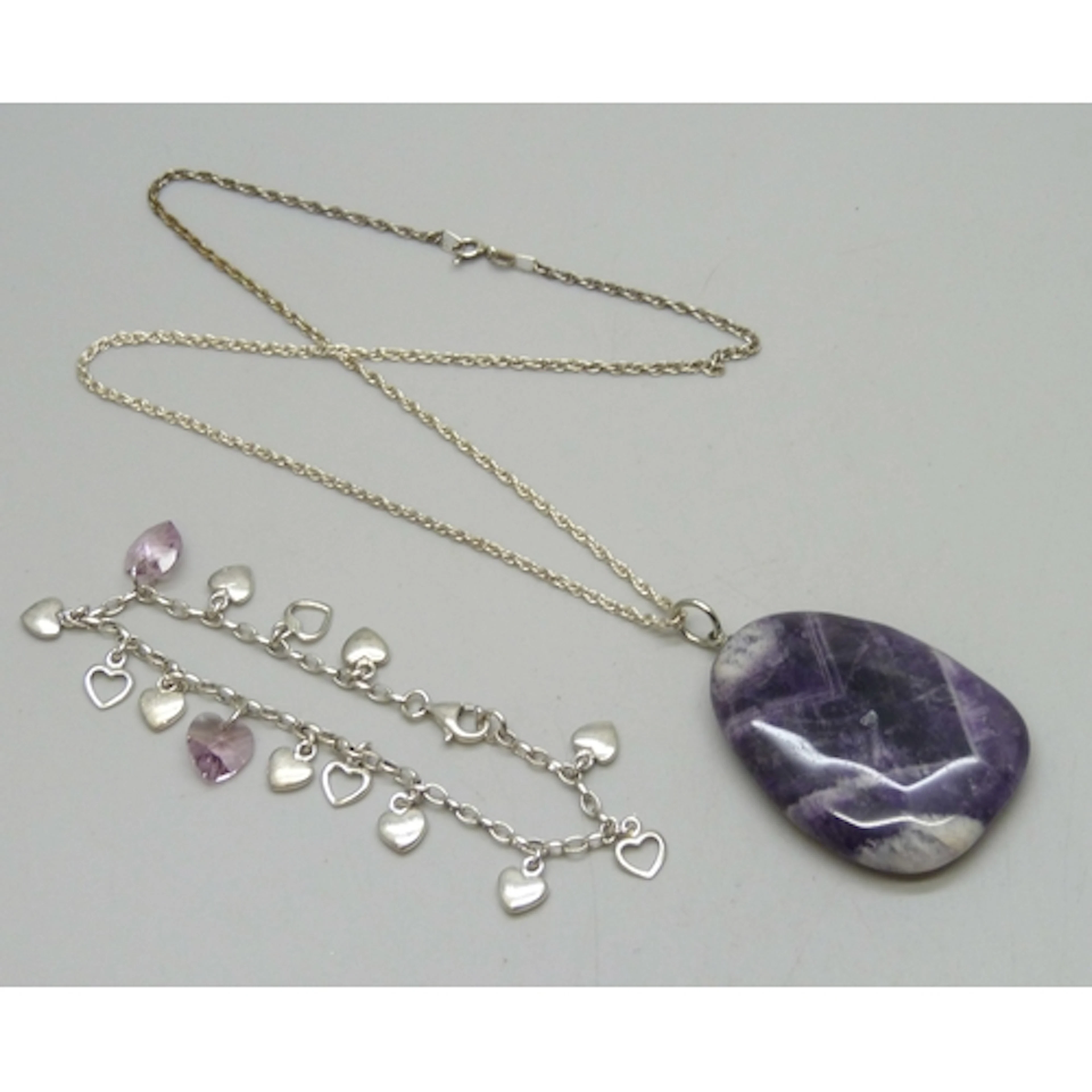 A silver heart bracelet, and a large Chevron amethyst pendan...