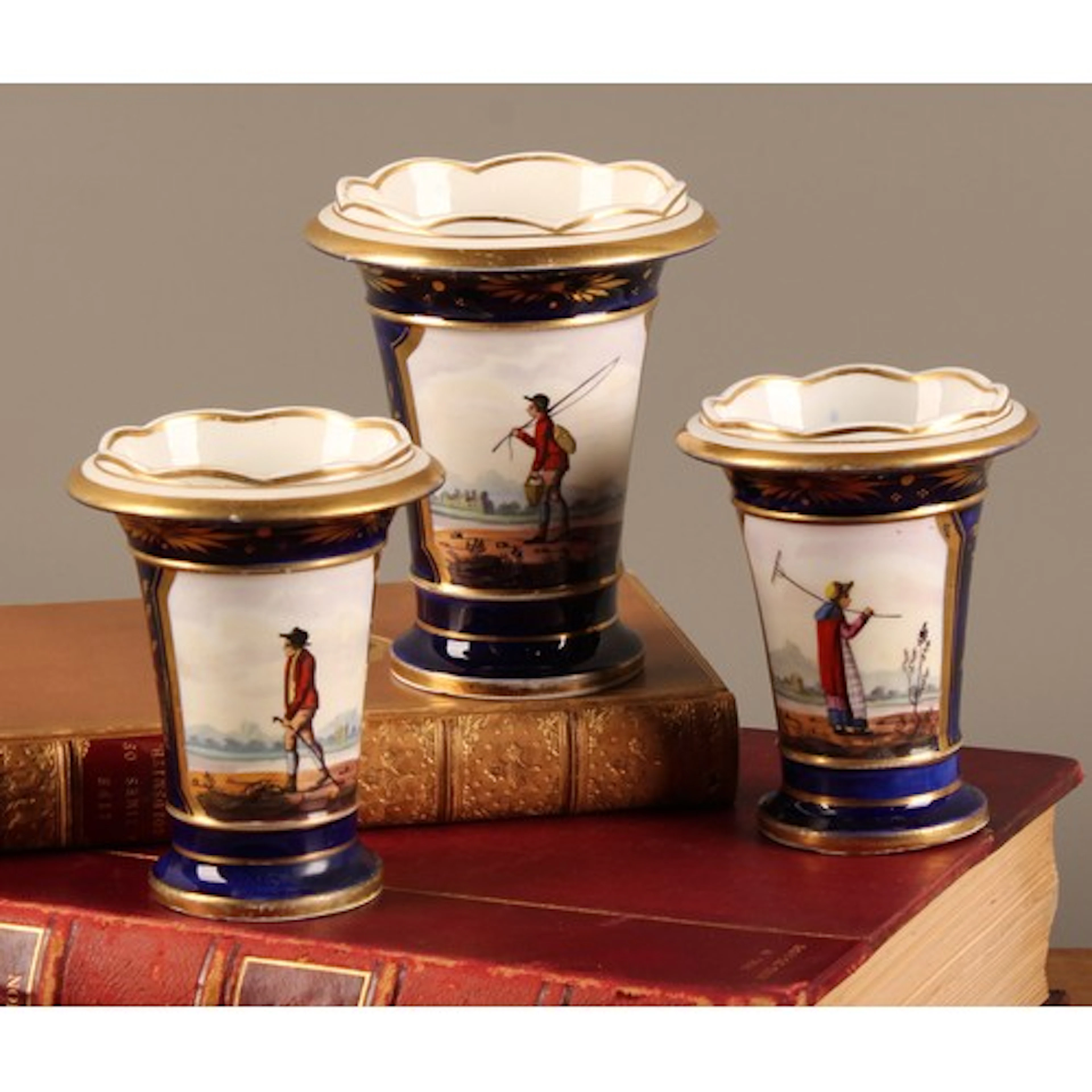 An English porcelain garniture of flared cylindrical spill v...