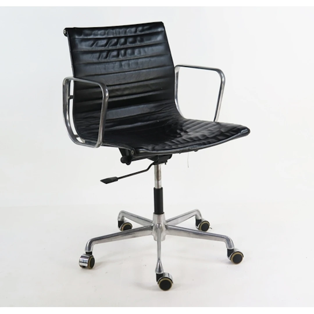 A Charles Eames ICF chrome and black leather swivel elbow ch...
